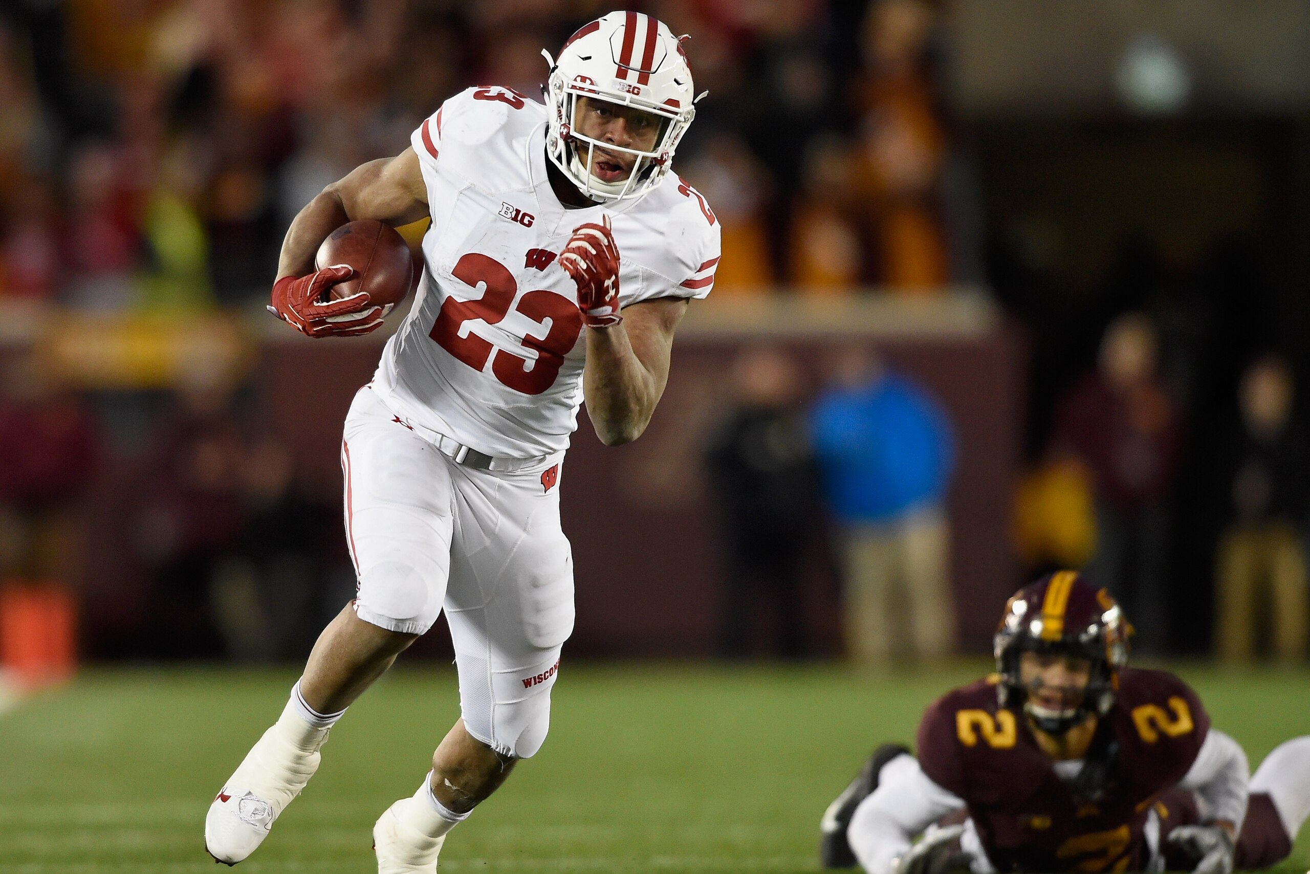 MINNEAPOLIS, MN - NOVEMBER 25: Jonathan Taylor #23 of the Wisconsin Badgers carries the ball for a touchdown after avoiding a tackle by Jacob Huff #2 of the Minnesota Golden Gophers during the fourth quarter of the game on November 25, 2017 at TCF Bank St