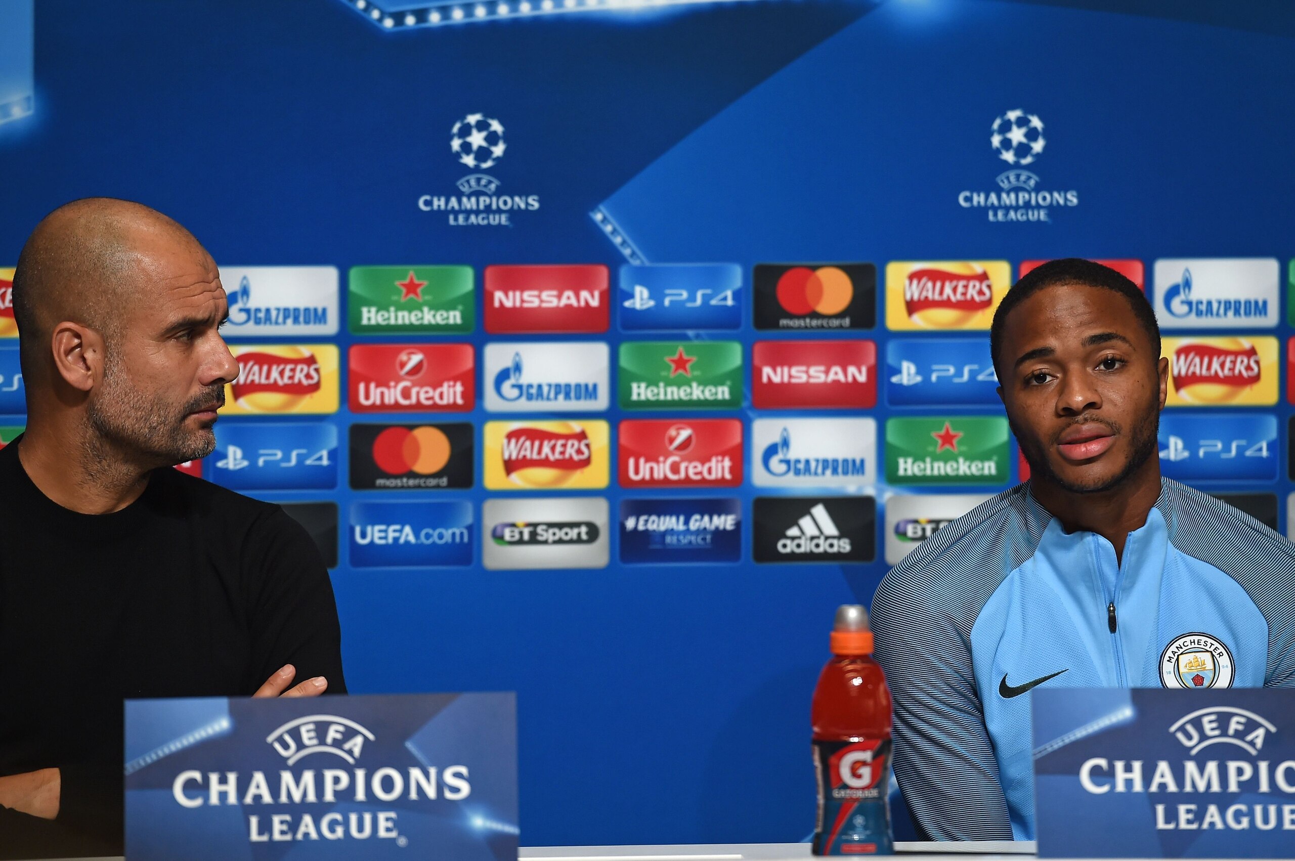 Manchester City's Spanish manager Pep Guardiola (L) watches as Manchester City's English midfielder Raheem Sterling (R) speaks at a press conference in Manchester, north west England on October 16, 2017, on the eve of their UEFA Champions League Group F m