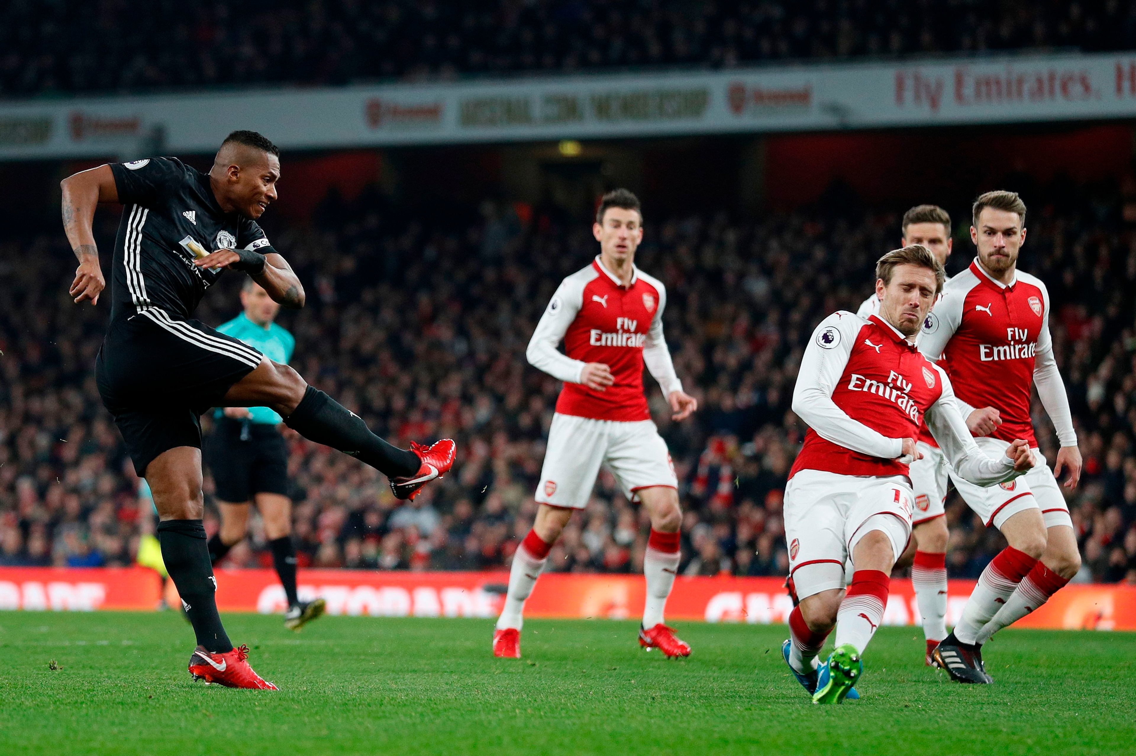 Manchester United's Ecuadorian midfielder Antonio Valencia (L) scores the opening goal during the English Premier League football match between Arsenal and Manchester United at the Emirates Stadium in London on December 2, 2017.  / AFP PHOTO / Adrian DENN