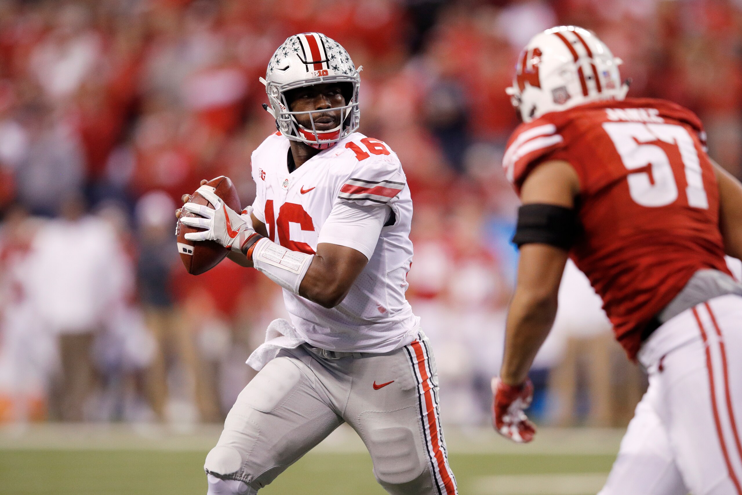 INDIANAPOLIS, IN - DECEMBER 02: J.T. Barrett #16 of the Ohio State Buckeyes looks to pass while under pressure from Alec James #57 of the Wisconsin Badgers during the Big Ten Championship at Lucas Oil Stadium on December 2, 2017 in Indianapolis, Indiana. INDIANAPOLIS, IN - DECEMBER 02: J.T. Barrett #16 of the Ohio State Buckeyes looks to pass while under pressure from Alec James #57 of the Wisconsin Badgers during the Big Ten Championship at Lucas Oil Stadium on December 2, 2017 in Indianapolis, Indiana.