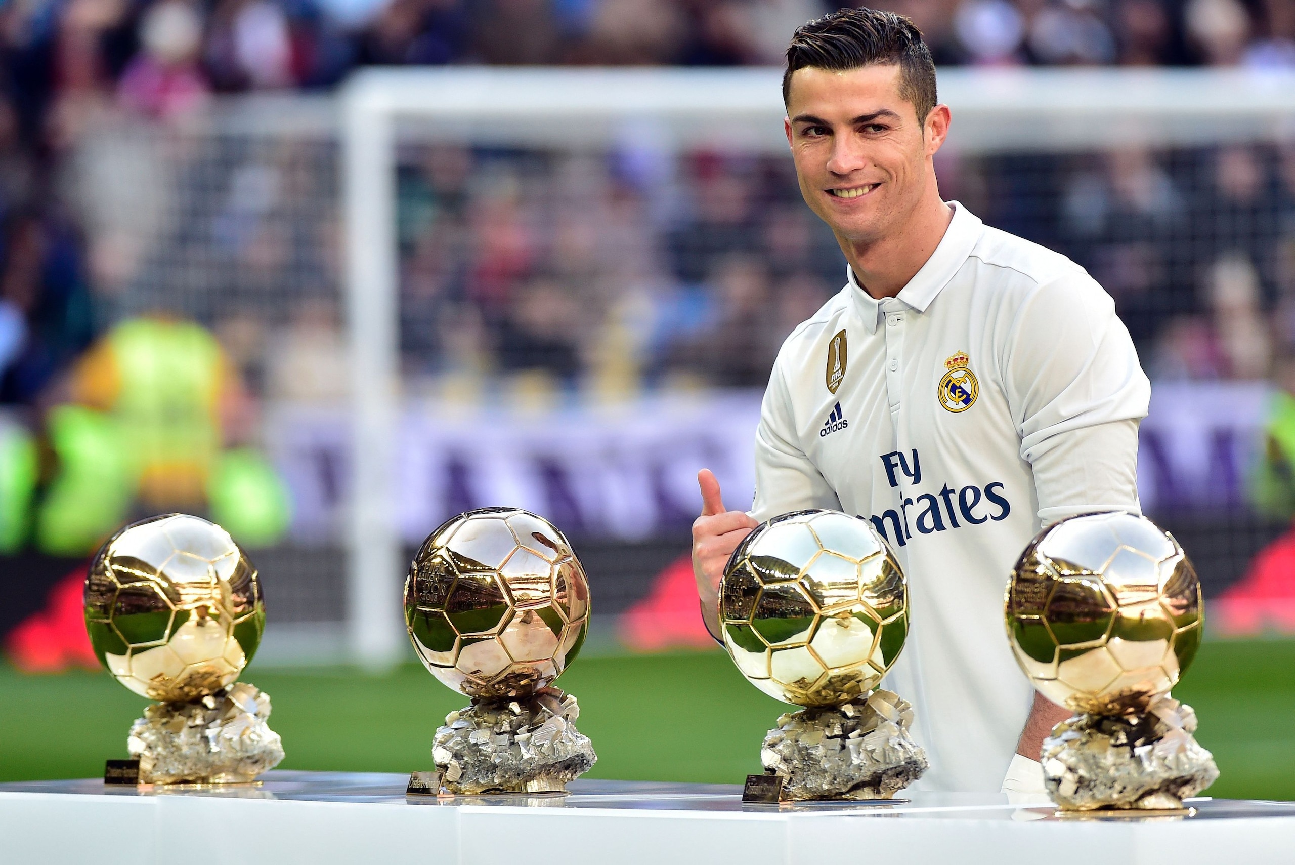 TOPSHOT - Real Madrid's Portuguese forward Cristiano Ronaldo poses with his four Ballon d'Or France Football trophies before the Spanish league football match Real Madrid CF vs Granada FC at the Santiago Bernabeu stadium in Madrid on January 7, 2017. / AF