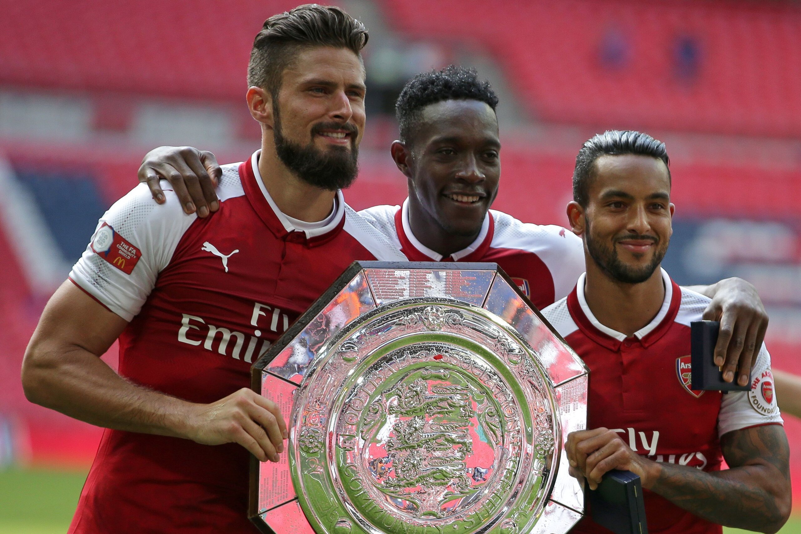 Arsenal's French striker Olivier Giroud (L), Arsenal's English striker Danny Welbeck (C) and Arsenal's English midfielder Theo Walcott (R) pose with the trophy as they celebrate after their victory in the English FA Community Shield football match between