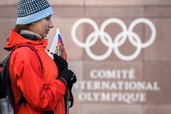 A supporter stands with a Russian flag in front of the logo of the International Olympic Committee (IOC) at the headquarters on December 5, 2017 in Pully near Lausanne.
The International Olympic Committee meets to decide whether to bar Russia from the 201