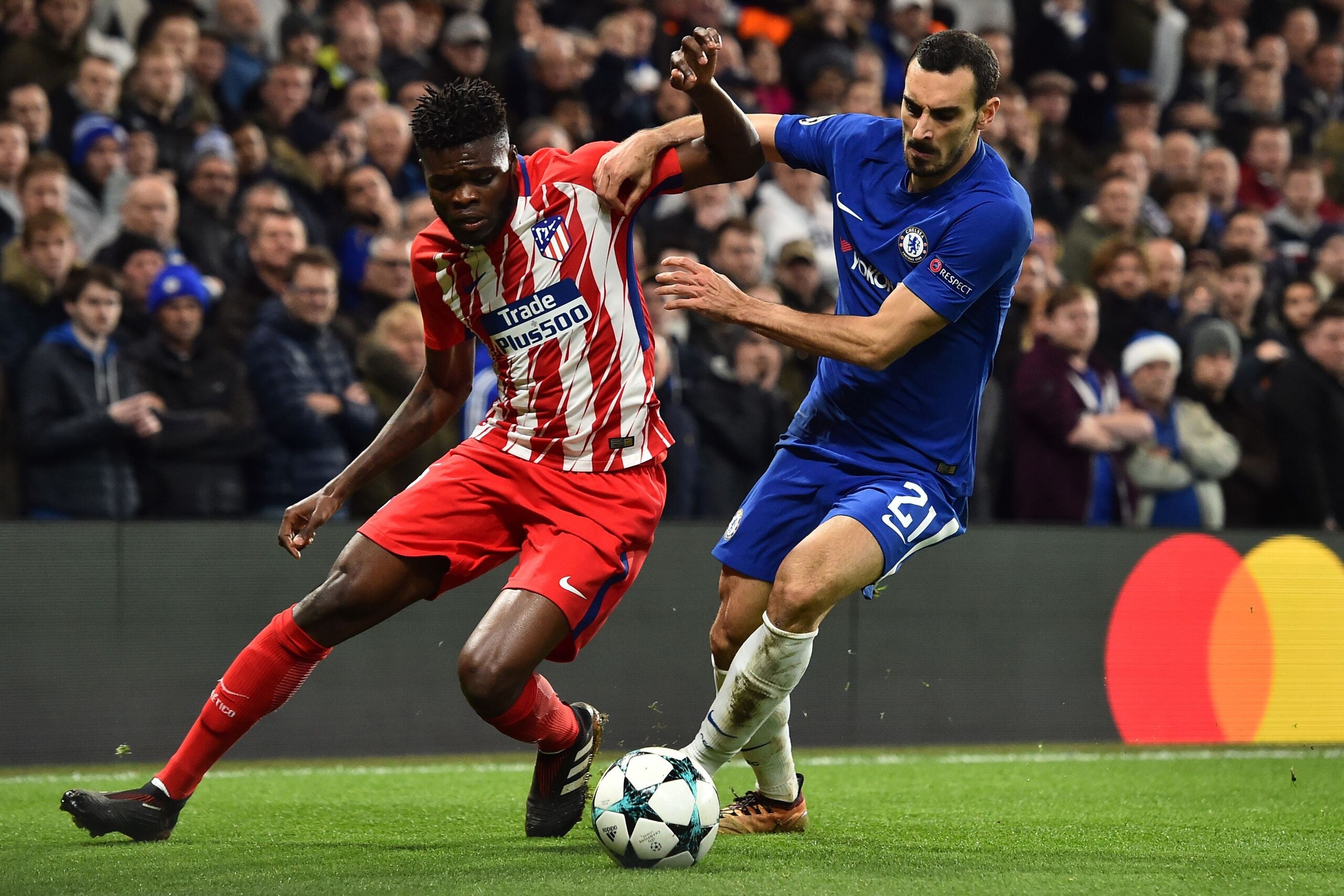 Atletico Madrid's Ghanaian midfielder Thomas (L) blocks Chelsea's Italian defender Davide Zappacosta during a UEFA Champions League Group C football match between Chelsea and Atletico Madrid at Stamford Bridge in London on December 5, 2017. / AFP PHOTO / Atletico Madrid's Ghanaian midfielder Thomas (L) blocks Chelsea's Italian defender Davide Zappacosta during a UEFA Champions League Group C football match between Chelsea and Atletico Madrid at Stamford Bridge in London on December 5, 2017. / AFP PHOTO /