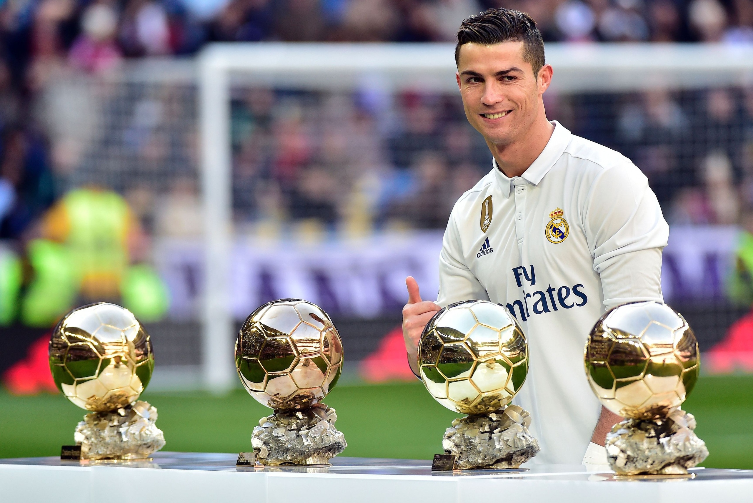 TOPSHOT - Real Madrid's Portuguese forward Cristiano Ronaldo poses with his four Ballon d'Or France Football trophies before the Spanish league football match Real Madrid CF vs Granada FC at the Santiago Bernabeu stadium in Madrid on January 7, 2017. / AF
