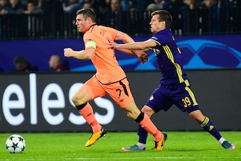 Liverpool's British midfielder James Milner (L) runs with the ball as Maribor's Slovenian midfielder Damjan Bohar (R) tries to tackle him during the UEFA Champions League group E football match between NK Maribor and Liverpool at the Ljudski vrt Stadium, 
