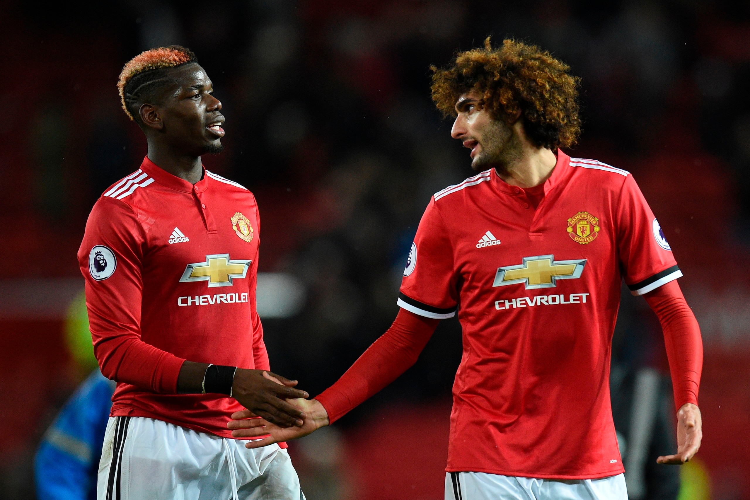 Manchester United's Belgian midfielder Marouane Fellaini (R) shakes hands with Manchester United's French midfielder Paul Pogba (L) during the English Premier League football match between Manchester United and Brighton and Hove Albion at Old Trafford in 