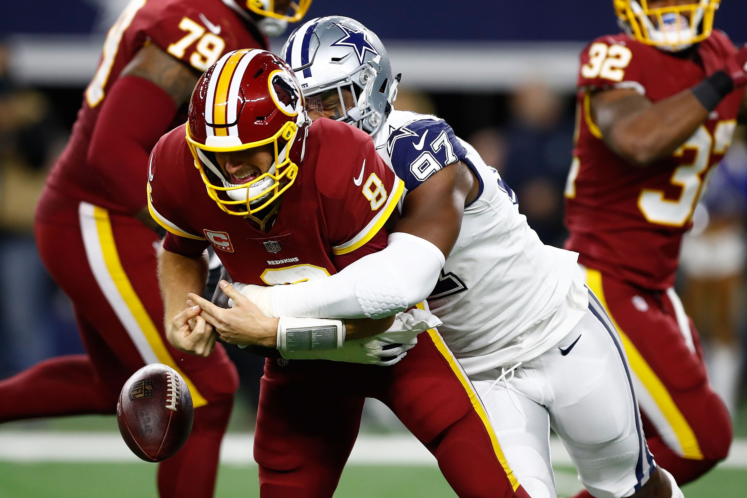 ARLINGTON, TX - NOVEMBER 30:  Kirk Cousins #8 of the Washington Redskins fumbles the ball after a hit by Taco Charlton #97 of the Dallas Cowboys in the second quarter of a football game at AT&T Stadium on November 30, 2017 in Arlington, Texas.  (Photo by 
