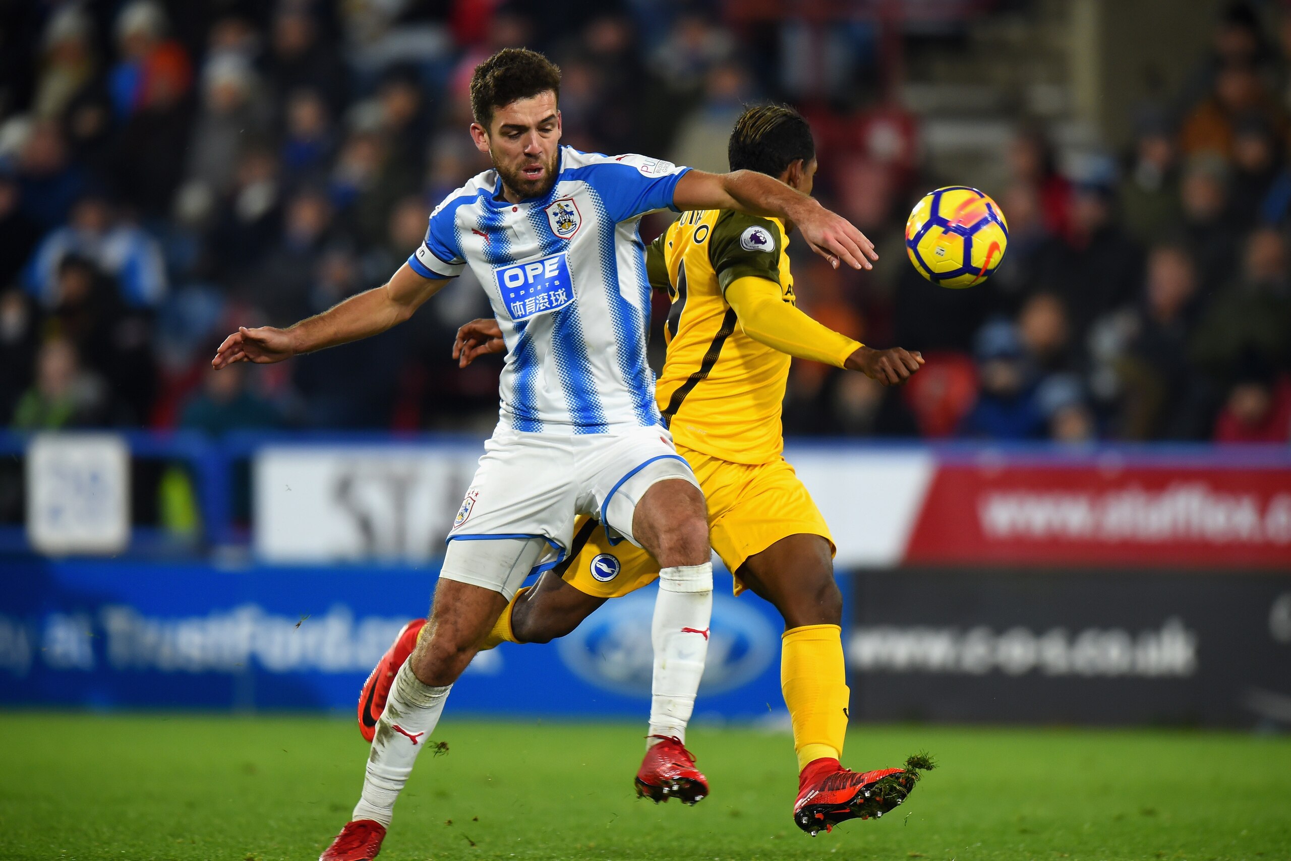 HUDDERSFIELD, ENGLAND - DECEMBER 09: Christopher Schindler of Huddersfield Towntackles Jose Izquierdo of Brighton and Hove Albion during the Premier League match between Huddersfield Town and Brighton and Hove Albion at John Smith's Stadium on December 9 HUDDERSFIELD, ENGLAND - DECEMBER 09: Christopher Schindler of Huddersfield Towntackles Jose Izquierdo of Brighton and Hove Albion during the Premier League match between Huddersfield Town and Brighton and Hove Albion at John Smith's Stadium on December 9