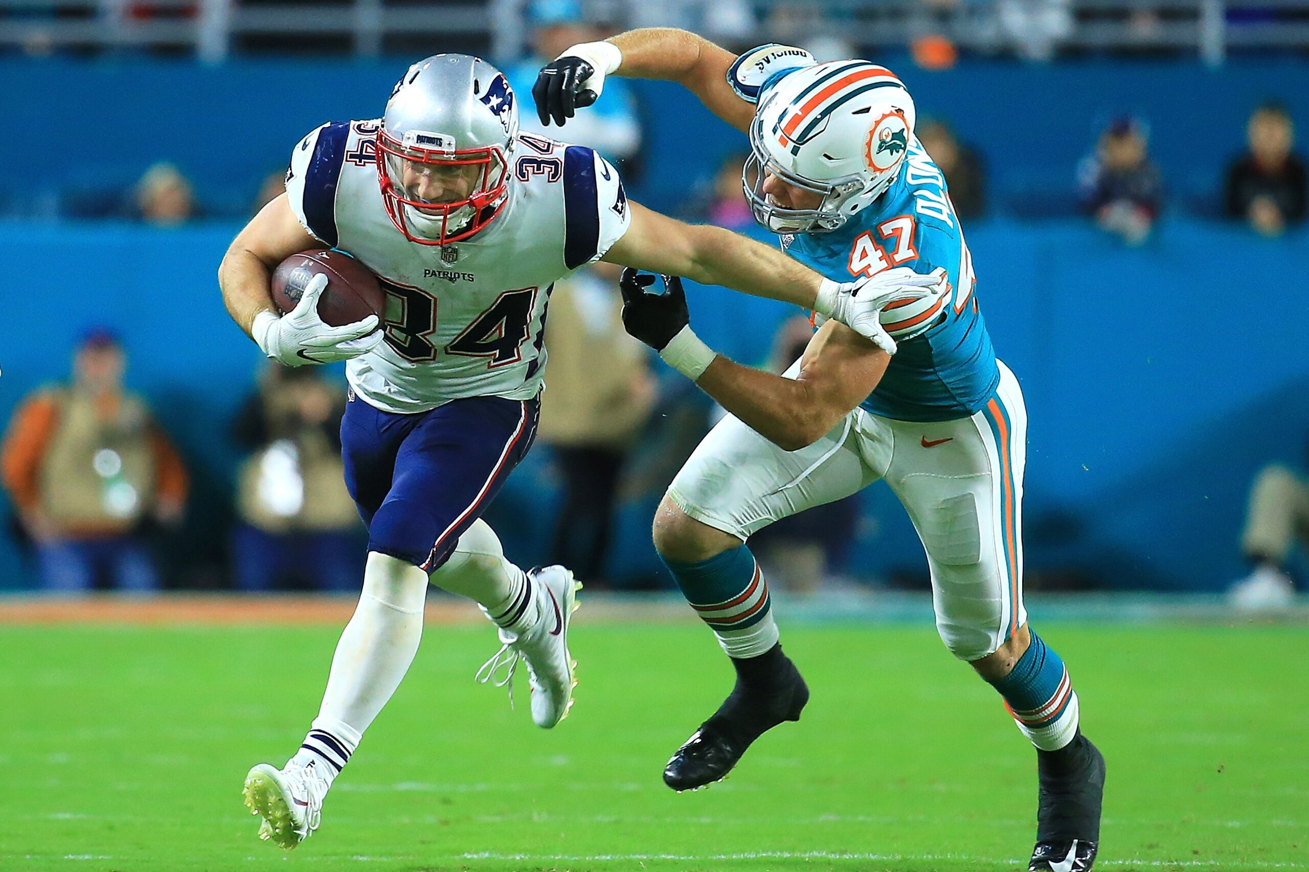 MIAMI GARDENS, FL - DECEMBER 11: Rex Burkhead #34 of the New England Patriots tries to avoid the tackle from Kiko Alonso #47 of the Miami Dolphins during the second quarter at Hard Rock Stadium on December 11, 2017 in Miami Gardens, Florida.  (Photo by Ch
