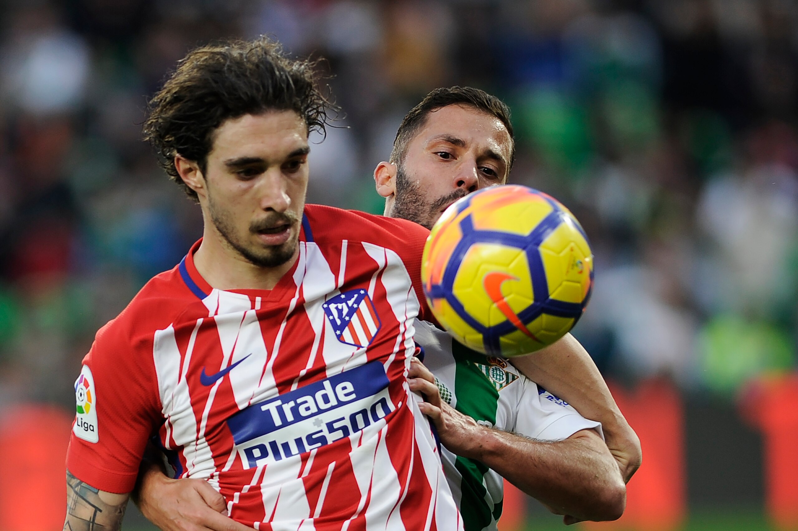 Atletico Madrid's Croatian defender Sime Vrsaljko (front) challenges Real Betis' Danish defender Riza Durmisi during the Spanish league football match between Real Betis and Atletico Madrid at the Benito Villamarin Stadium in Sevilla on December 10, 2017.