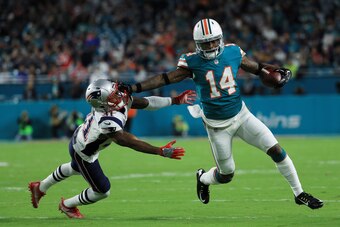 MIAMI GARDENS, FL - DECEMBER 11:  Jarvis Landry #14 of the Miami Dolphins tries to avoid the tackle of  Jonathan Jones #31 of the New England Patriots in the first quarter at Hard Rock Stadium on December 11, 2017 in Miami Gardens, Florida.  (Photo by Mik