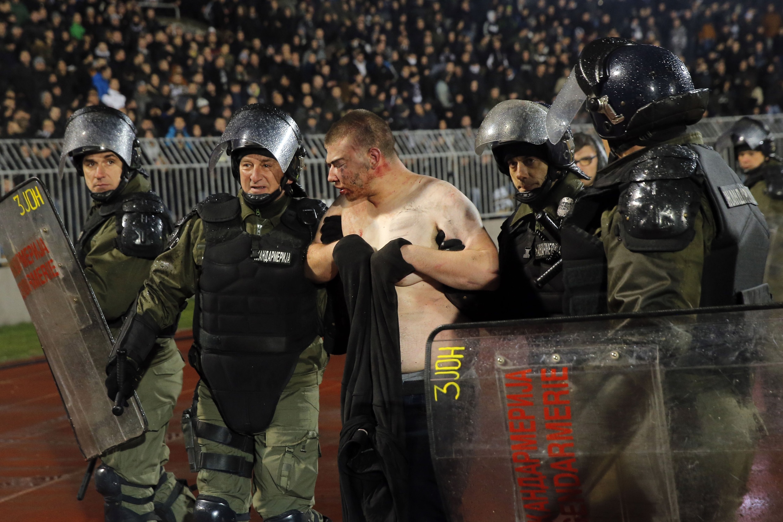 Policemen arrest a Partizan Belgrade's hooligan after clashes between two groups of Partizan Belgrade's supporters during the Serbian Superleague derby football match between Partizan Belgrade and Crvena Zvezda (Red Star), on December 13, 2017 in Belgrade