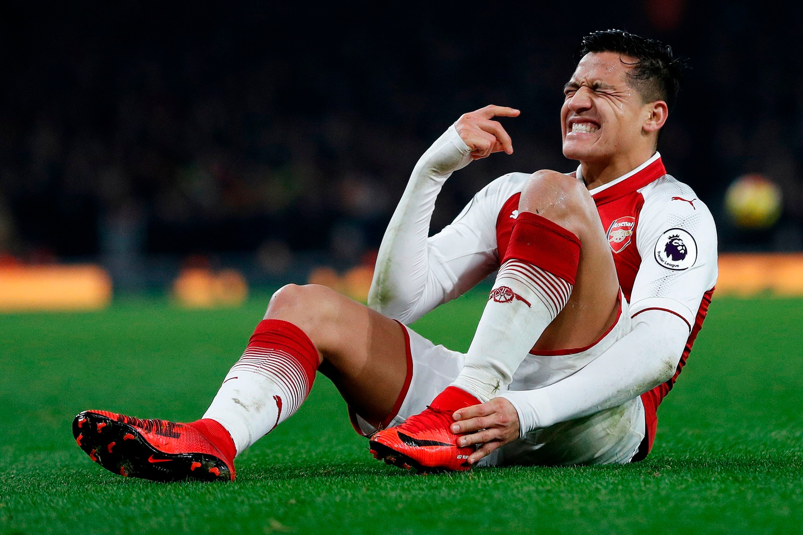 Arsenal's Chilean striker Alexis Sanchez reacts after a challenge from Manchester United's Argentinian defender Marcos Rojo during the English Premier League football match between Arsenal and Manchester United at the Emirates Stadium in London on Decembe