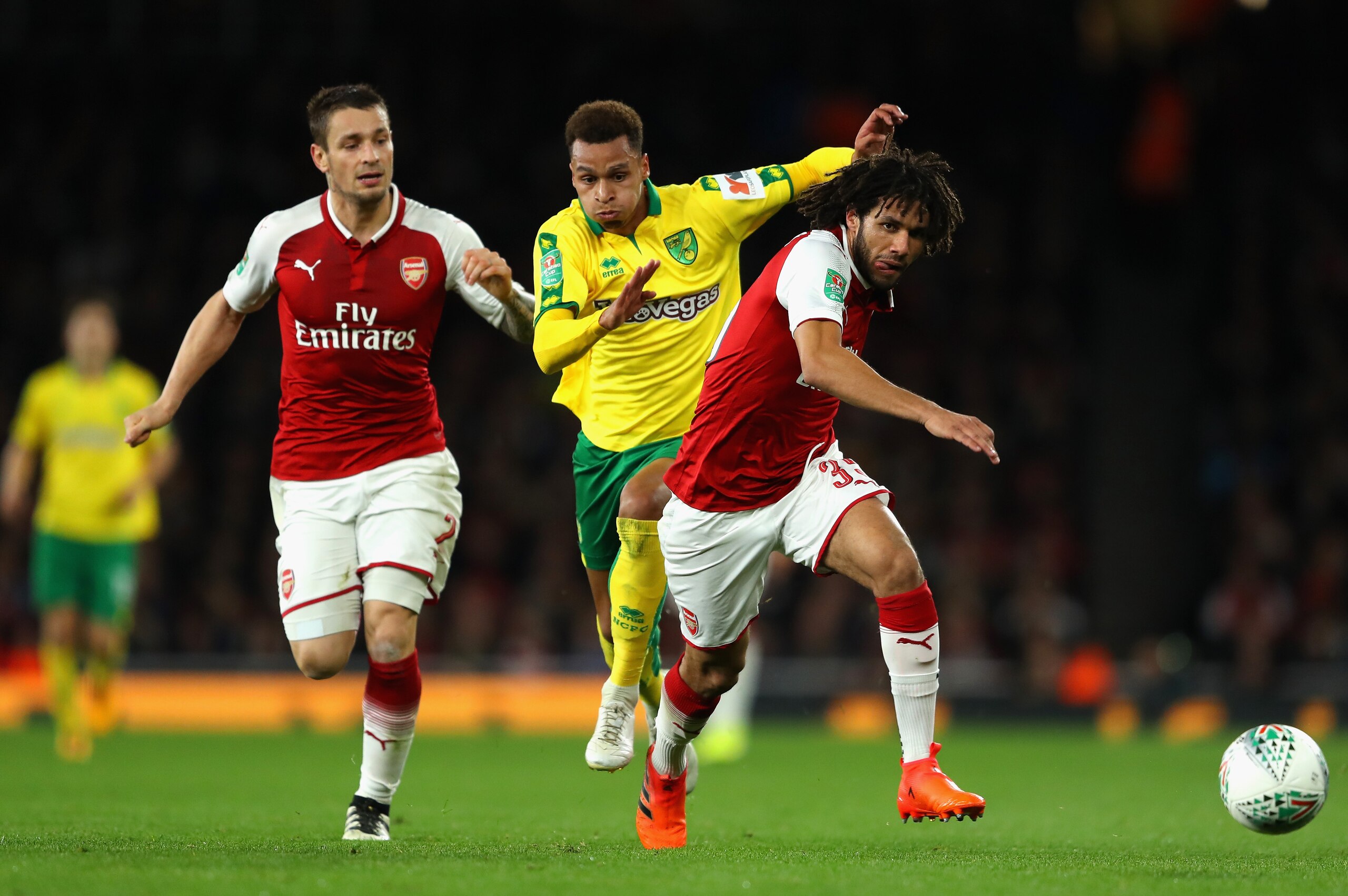 LONDON, ENGLAND - OCTOBER 24:   Mohamed Elneny of Arsenal goes past Josh Murphy of Norwich City as Mathieu Debuchy of Arsenal looks on during the Carabao Cup Fourth Round match between Arsenal and Norwich City at Emirates Stadium on October 24, 2017 in Lo