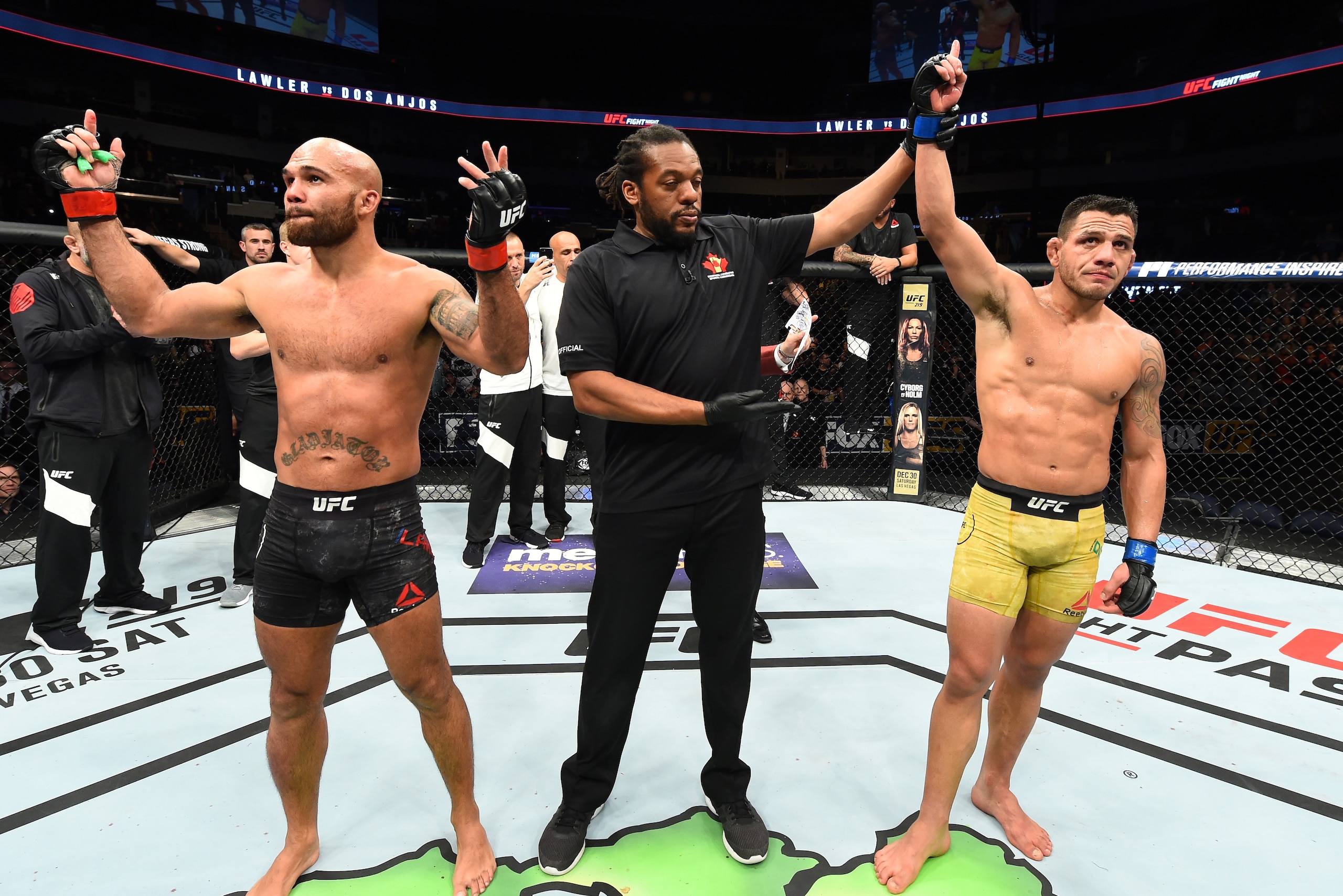 WINNIPEG, CANADA - DECEMBER 16:  (R-L) Rafael Dos Anjos of Brazil celebrates his victory over Robbie Lawler in their welterweight bout during the UFC Fight Night event at Bell MTS Place on December 16, 2017 in Winnipeg, Manitoba, Canada. (Photo by Josh He
