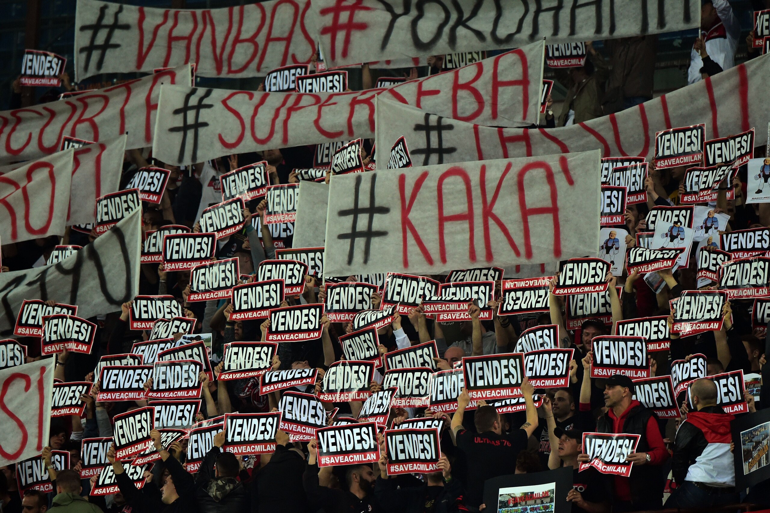 AC Milan's supporters hold posters reading 'Vendesi' (for sale) and a flag reading 'Kaka' during the Italian Serie A football match between AC Milan and Sampdoria at San Siro Stadium in Milan on April 12, 2015. AFP PHOTO / GIUSEPPE CACACE        (Photo cr