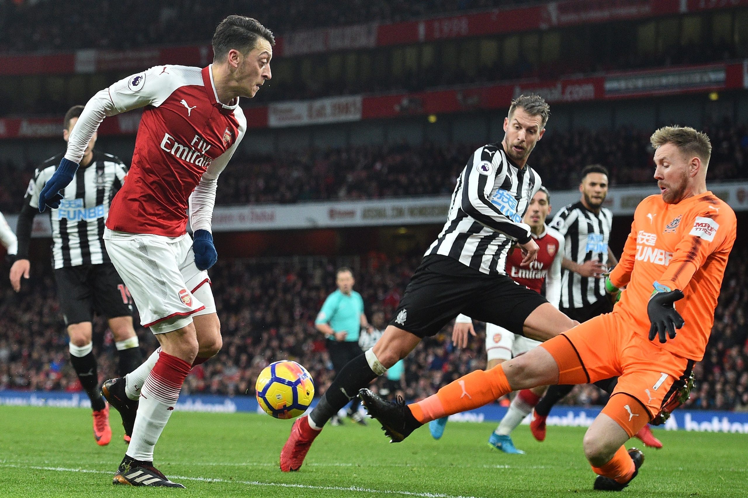 Newcastle United's English-born Irish goalkeeper Rob Elliot (R) comes out to try to block an attempt by Arsenal's German midfielder Mesut Ozil (L) during the English Premier League football match between Arsenal and Newcastle United at the Emirates Stadiu