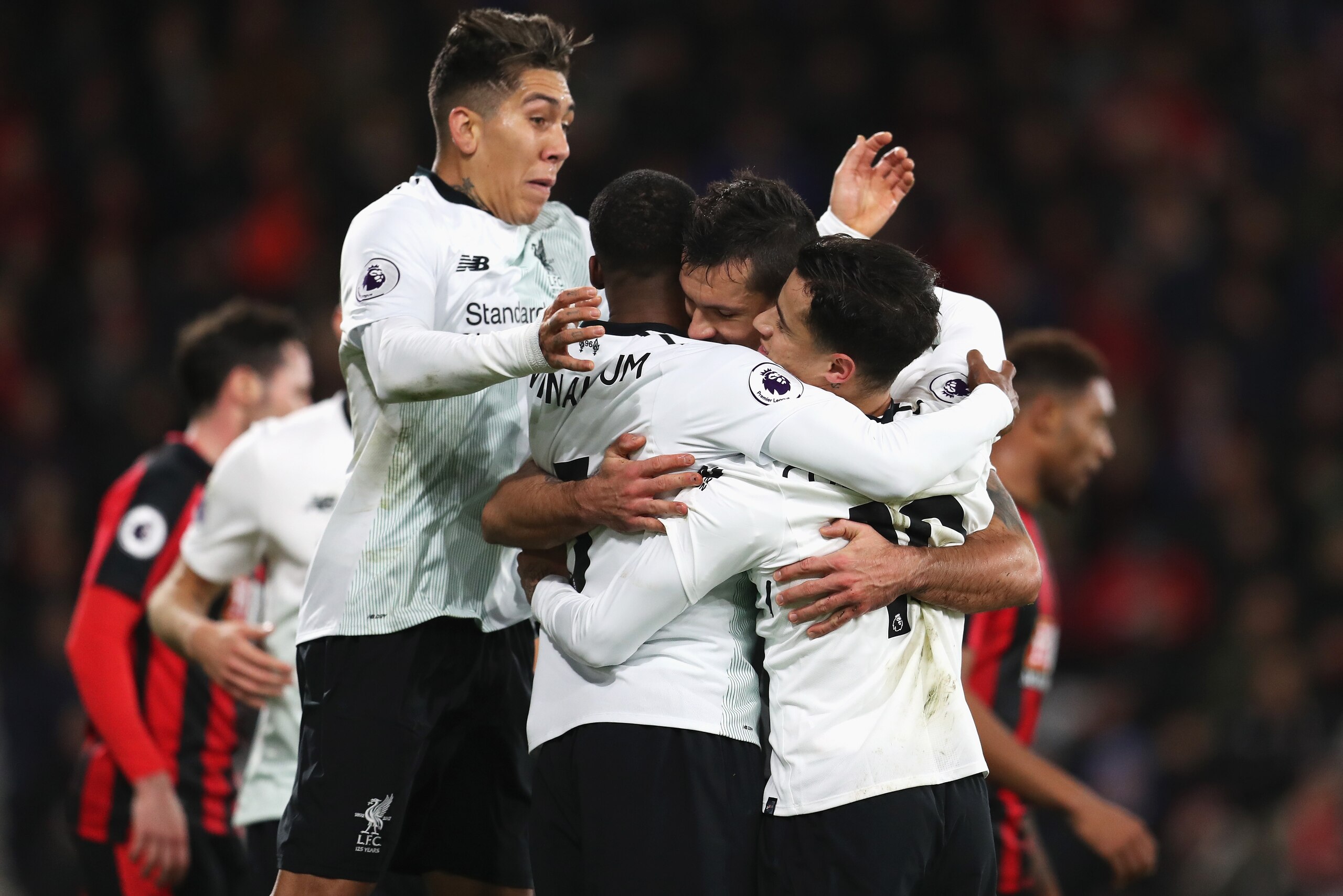 BOURNEMOUTH, ENGLAND - DECEMBER 17:  Roberto Firmino of Liverpool joins in Dejan Lovren's  celebrations with teammates Georginio Wijnaldum and Philippe Coutinho after scoring his sides second goal during the Premier League match between AFC Bournemouth an