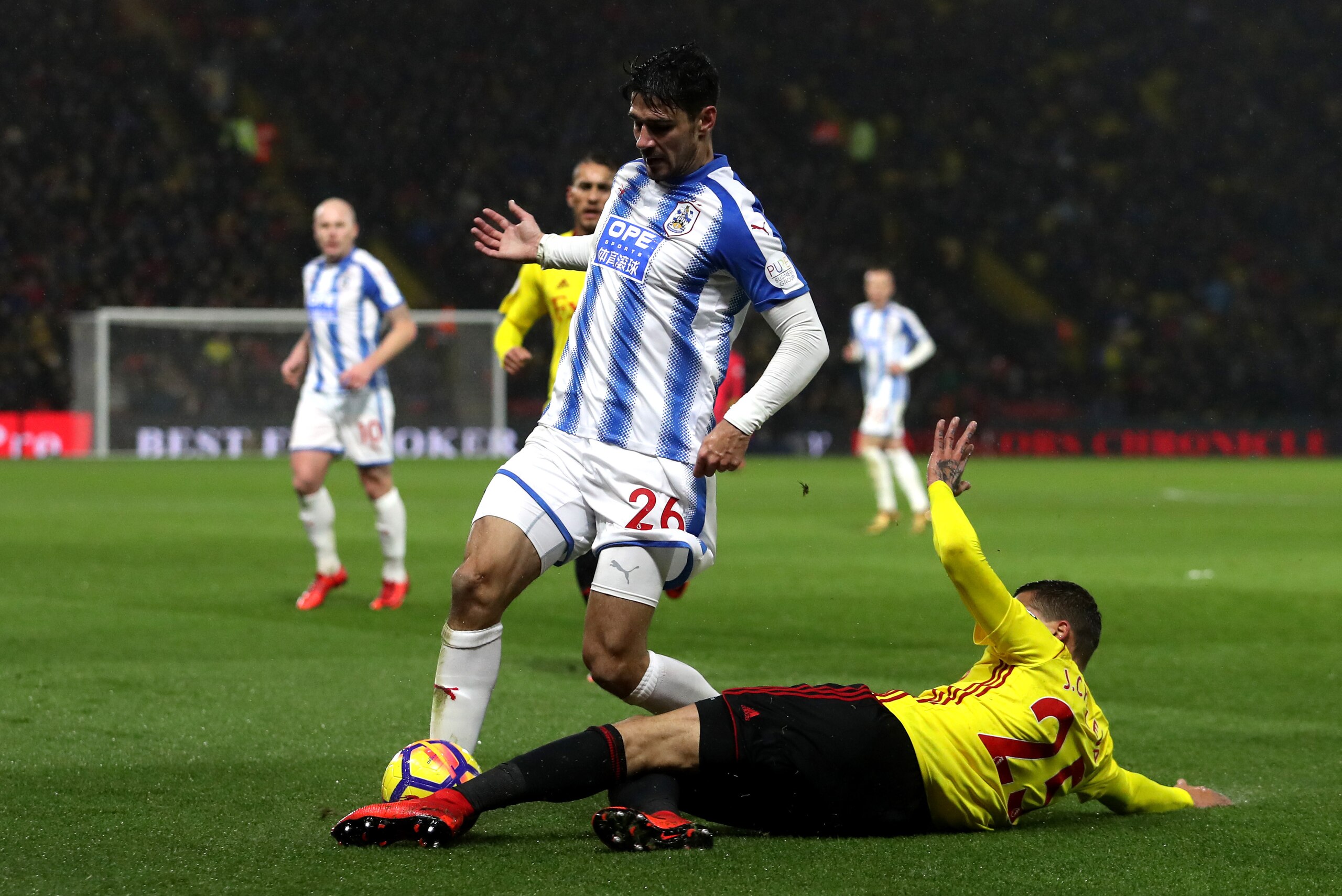 WATFORD, ENGLAND - DECEMBER 16: Jose Holebas of Watford tackles Christopher Schindler of Huddersfield Town during the Premier League match between Watford and Huddersfield Town at Vicarage Road on December 16, 2017 in Watford, England.  (Photo by Christop