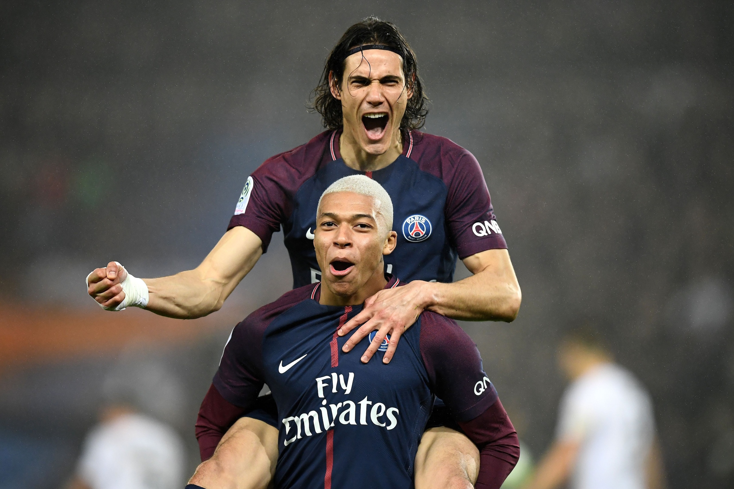 Paris Saint-Germain's French forward Kylian MBappe (bottom) celebrates with Paris Saint-Germain's Uruguayan forward Edinson Cavani after scoring during the French L1 football match between Paris Saint-Germain and Caen at the Parc des Princes stadium in Pa