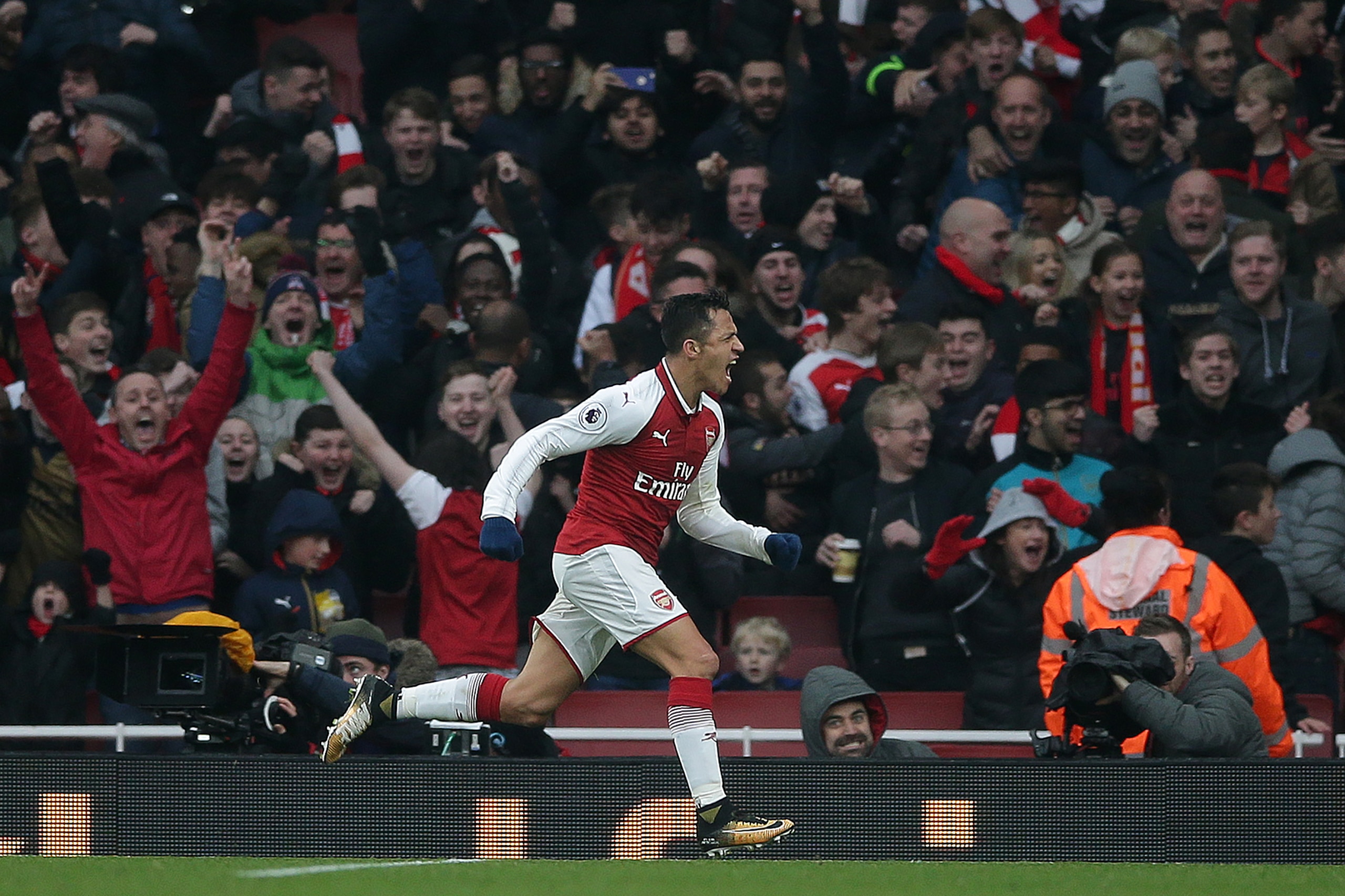 TOPSHOT - Arsenal's Chilean striker Alexis Sanchez celebrates scoring his team's second goal during the English Premier League football match between Arsenal and Tottenham Hotspur at the Emirates Stadium in London on November 18, 2017.  / AFP PHOTO / Dani