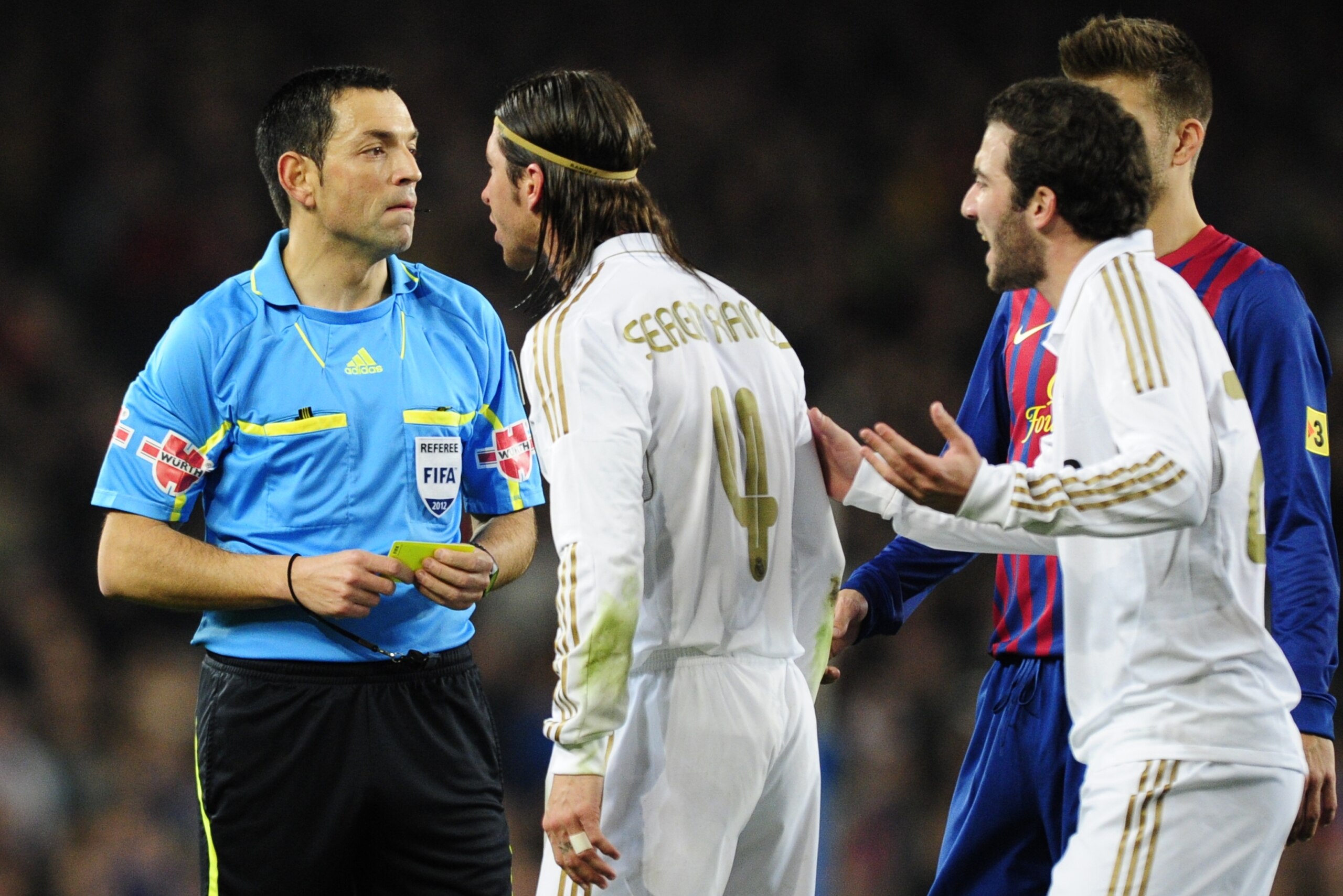 Real Madrid's defender Sergio Ramos (C) and Real Madrid's Argentinian forward Gonzalo Higuain (R) argue with referee Txeira Vitienes (L) during the second leg of the Spanish Cup quarter-final 'El clasico' football match Barcelona vs Real Madrid at the Cam
