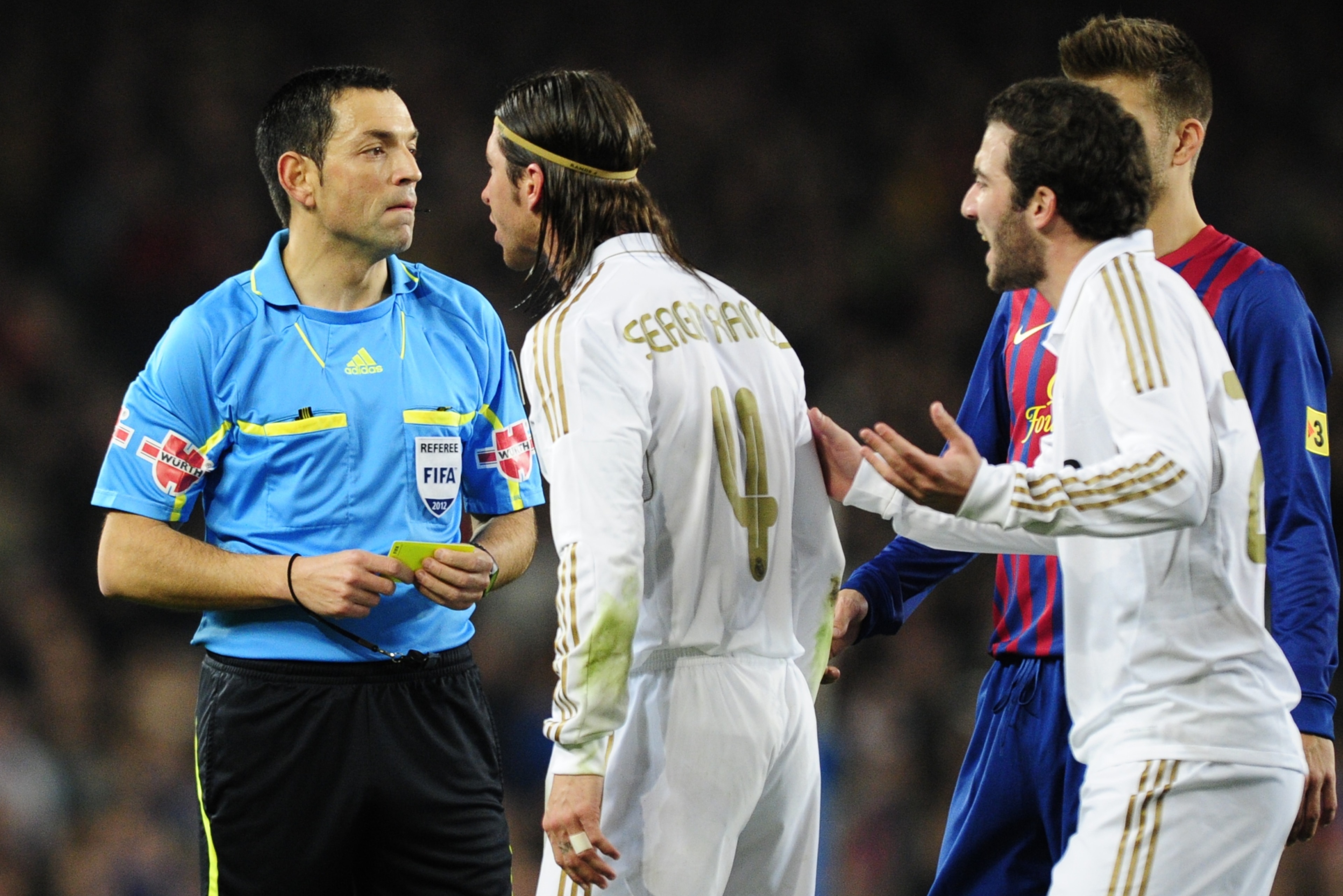 Real Madrid's defender Sergio Ramos (C) and Real Madrid's Argentinian forward Gonzalo Higuain (R) argue with referee Txeira Vitienes (L) during the second leg of the Spanish Cup quarter-final 'El clasico' football match Barcelona vs Real Madrid at the Cam