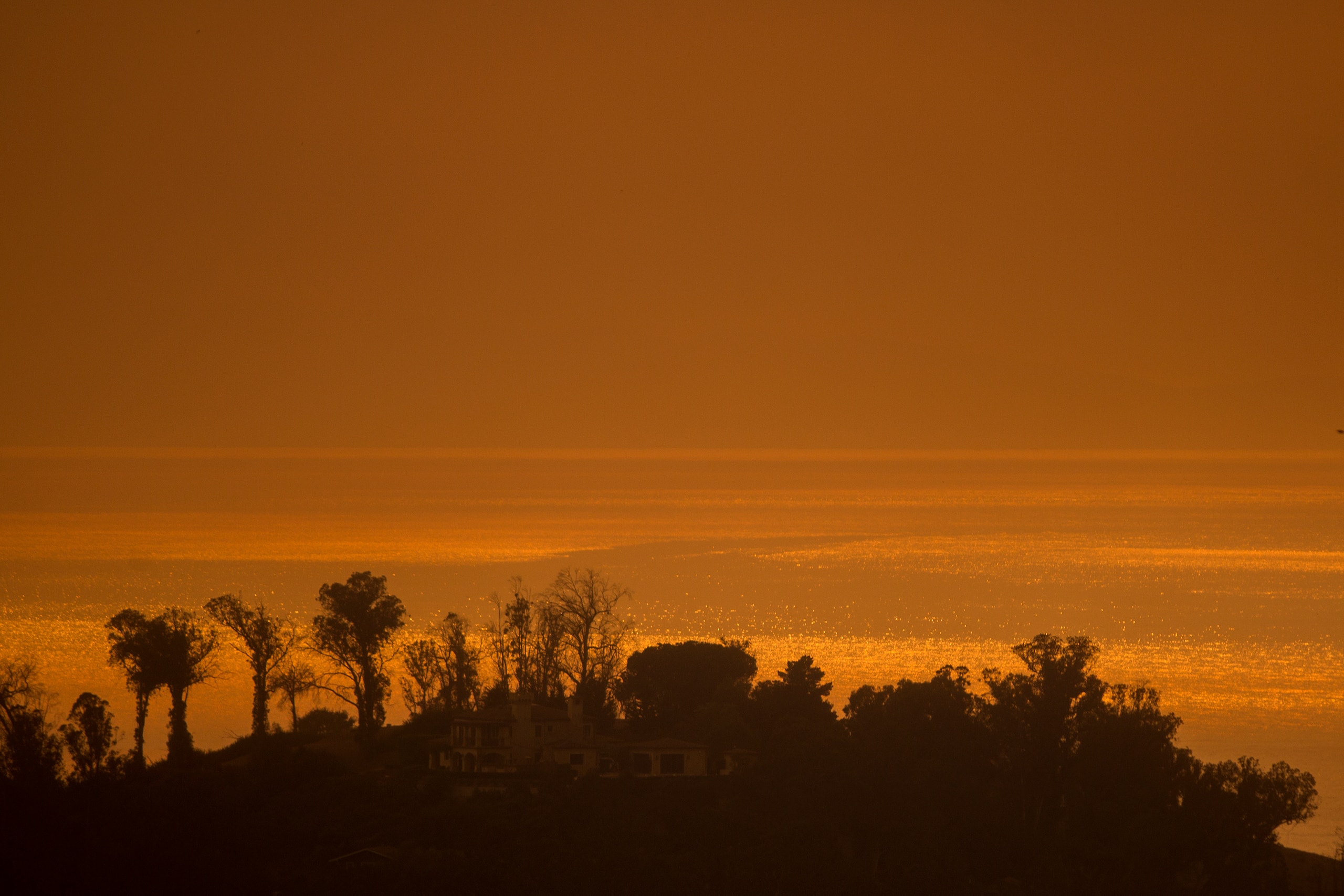 MONTECITO, CA - DECEMBER 16: Smoke fills the sky over the ocean beyond homes threatened by the Thomas Fire on December 16, 2017 in Montecito, California. The National Weather Service has issued red flag warnings of dangerous fire weather in Southern Calif