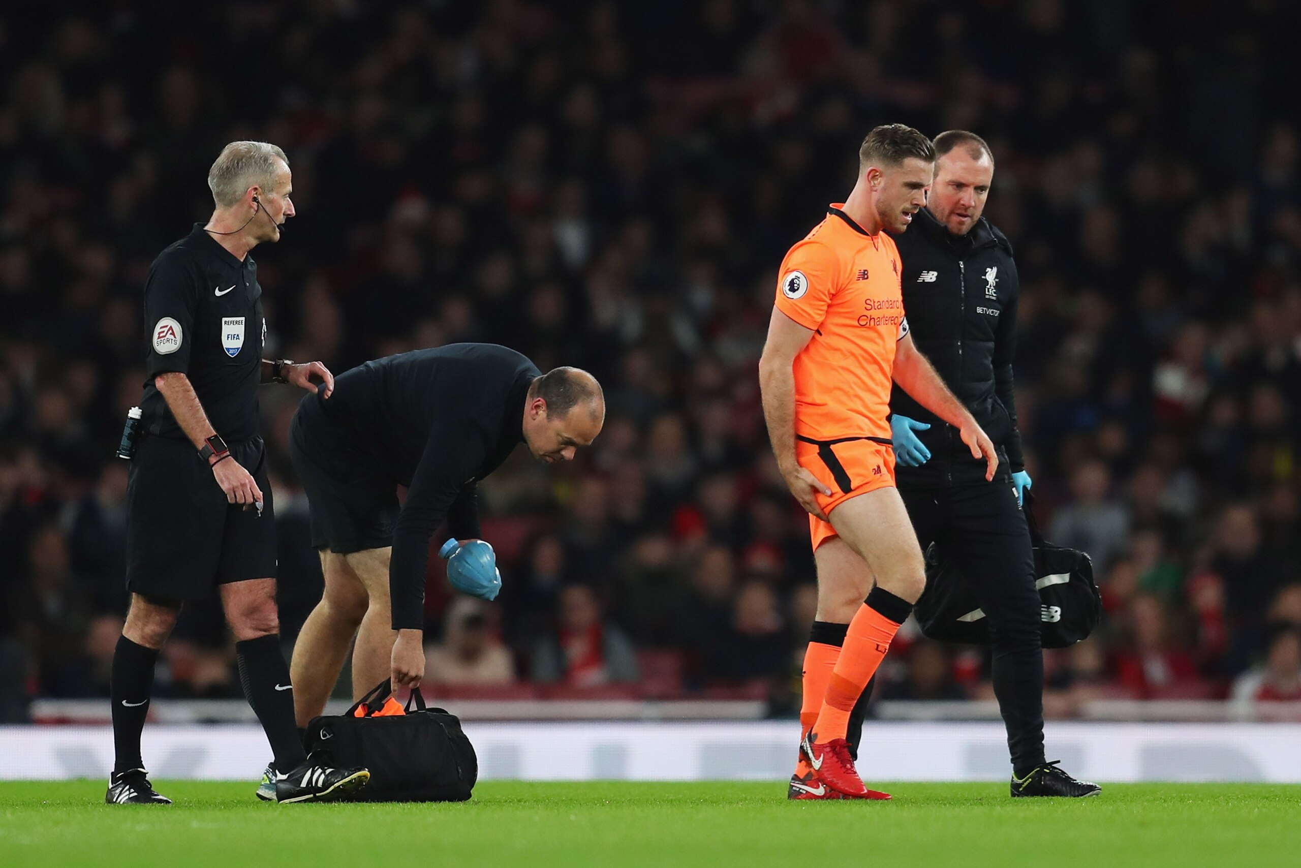 LONDON, ENGLAND - DECEMBER 22:  An injured Jordan Henderson of Liverpool (14) is given assistance during the Premier League match between Arsenal and Liverpool at Emirates Stadium on December 22, 2017 in London, England.  (Photo by Catherine Ivill/Getty I