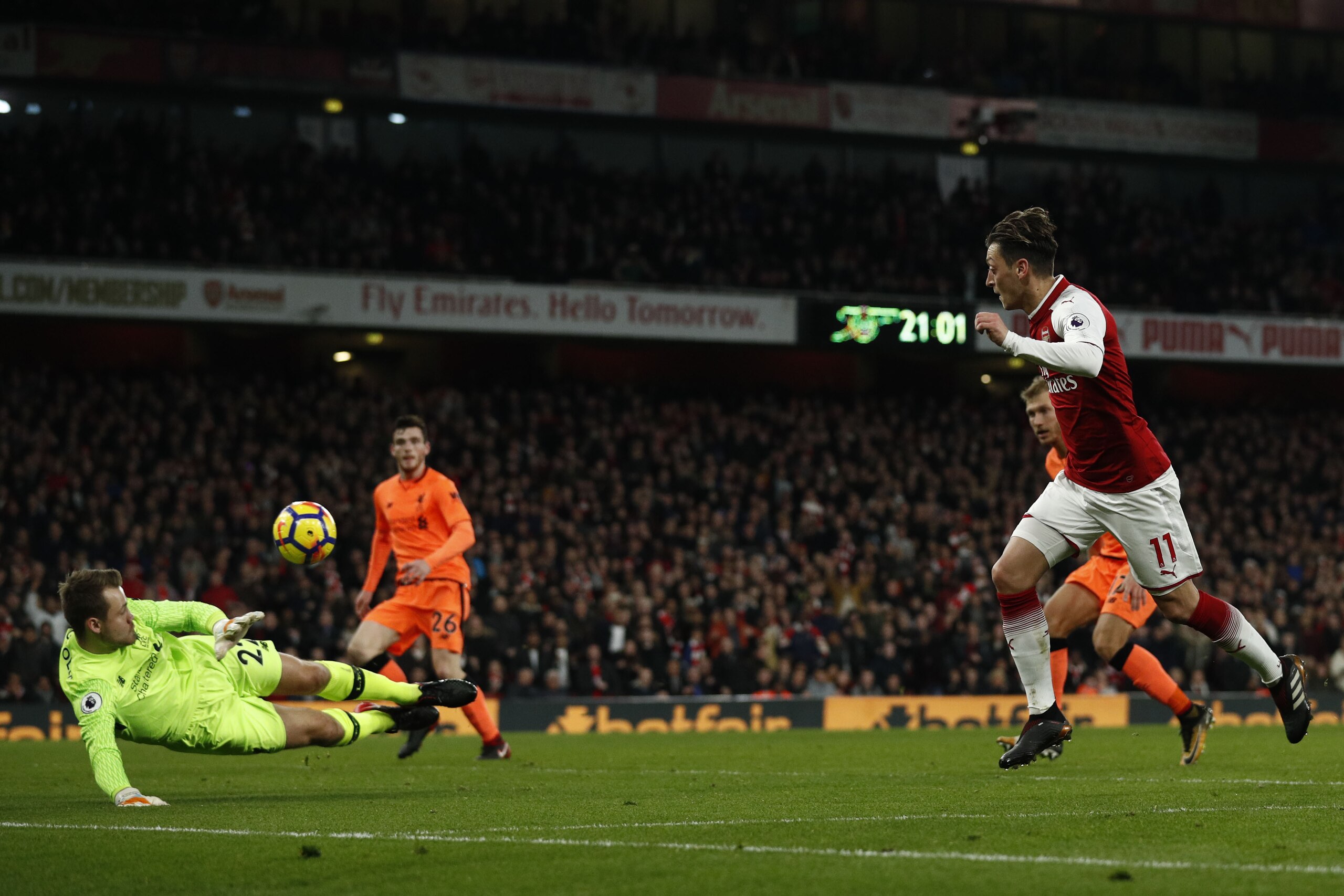 Arsenal's German midfielder Mesut Ozil (R) scores the team's third goal during the English Premier League football match between Arsenal and Liverpool at the Emirates Stadium in London on December 22, 2017.  / AFP PHOTO / Adrian DENNIS / RESTRICTED TO EDI