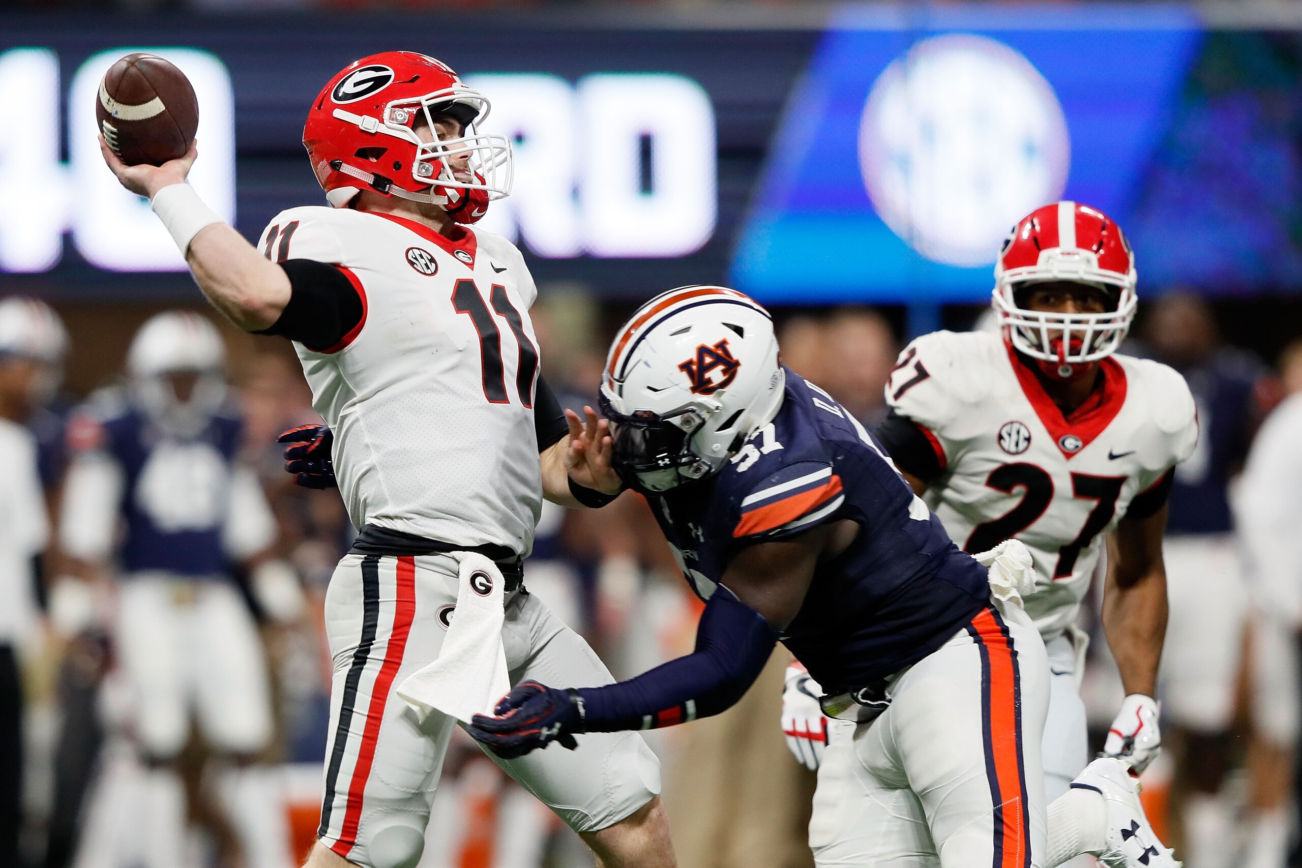 ATLANTA, GA - DECEMBER 02: Jake Fromm #11 of the Georgia Bulldogs throws a pass before the hit by Deshaun Davis #57 of the Auburn Tigers during the second half in the SEC Championship at Mercedes-Benz Stadium on December 2, 2017 in Atlanta, Georgia. (Phot ATLANTA, GA - DECEMBER 02: Jake Fromm #11 of the Georgia Bulldogs throws a pass before the hit by Deshaun Davis #57 of the Auburn Tigers during the second half in the SEC Championship at Mercedes-Benz Stadium on December 2, 2017 in Atlanta, Georgia. (Phot