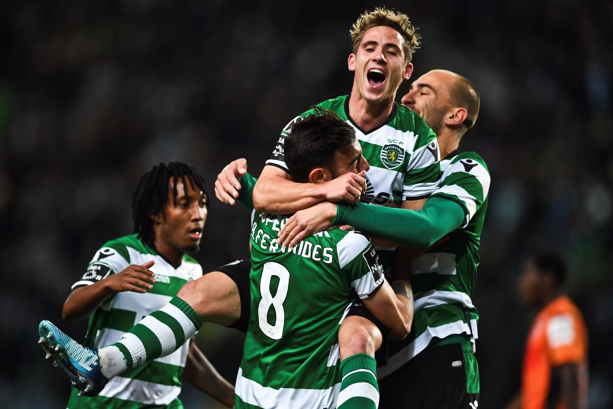 Sporting's Portuguese midfielder Bruno Fernandes (L) celebrates with Sporting's Dutch forward Bas Dost (C) and Sporting's forward Daniel Podence (R) after scoring during the Portuguese league football match Sporting CP against Portimonense SC at the Jose 