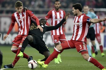 Olympiakos' Greek defender Panagiotis Retsos (L) and Spanish defender Alberto Botia (R) vy for the ball with Osmanlispor's Senegalese midfielder Badou Ndiaye during the UEFA Europa League round of 32 first leg football match between Olympiakos and Osmanli