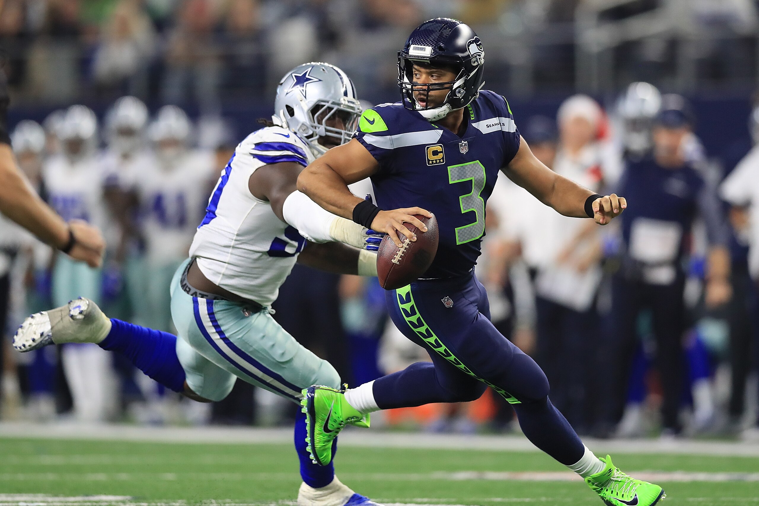 ARLINGTON, TX - DECEMBER 24:  Russell Wilson #3 of the Seattle Seahawks runs away from DeMarcus Lawrence #90 of the Dallas Cowboys in the second half at AT&T Stadium on December 24, 2017 in Arlington, Texas.  (Photo by Ronald Martinez/Getty Images)