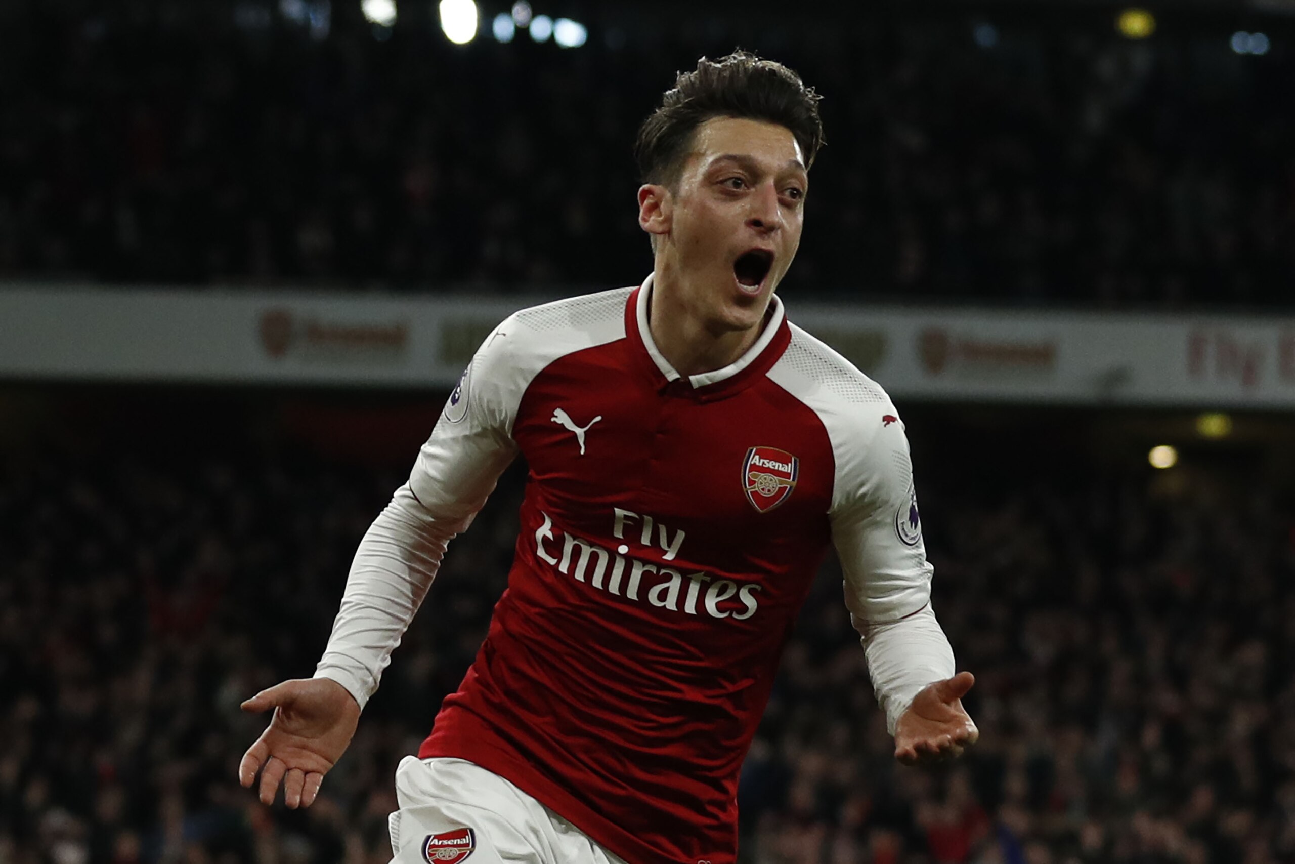 Arsenal's German midfielder Mesut Ozil celebrates scoring the team's second goal during the English Premier League football match between Arsenal and Liverpool at the Emirates Stadium in London on December 22, 2017.  / AFP PHOTO / Adrian DENNIS / RESTRICT
