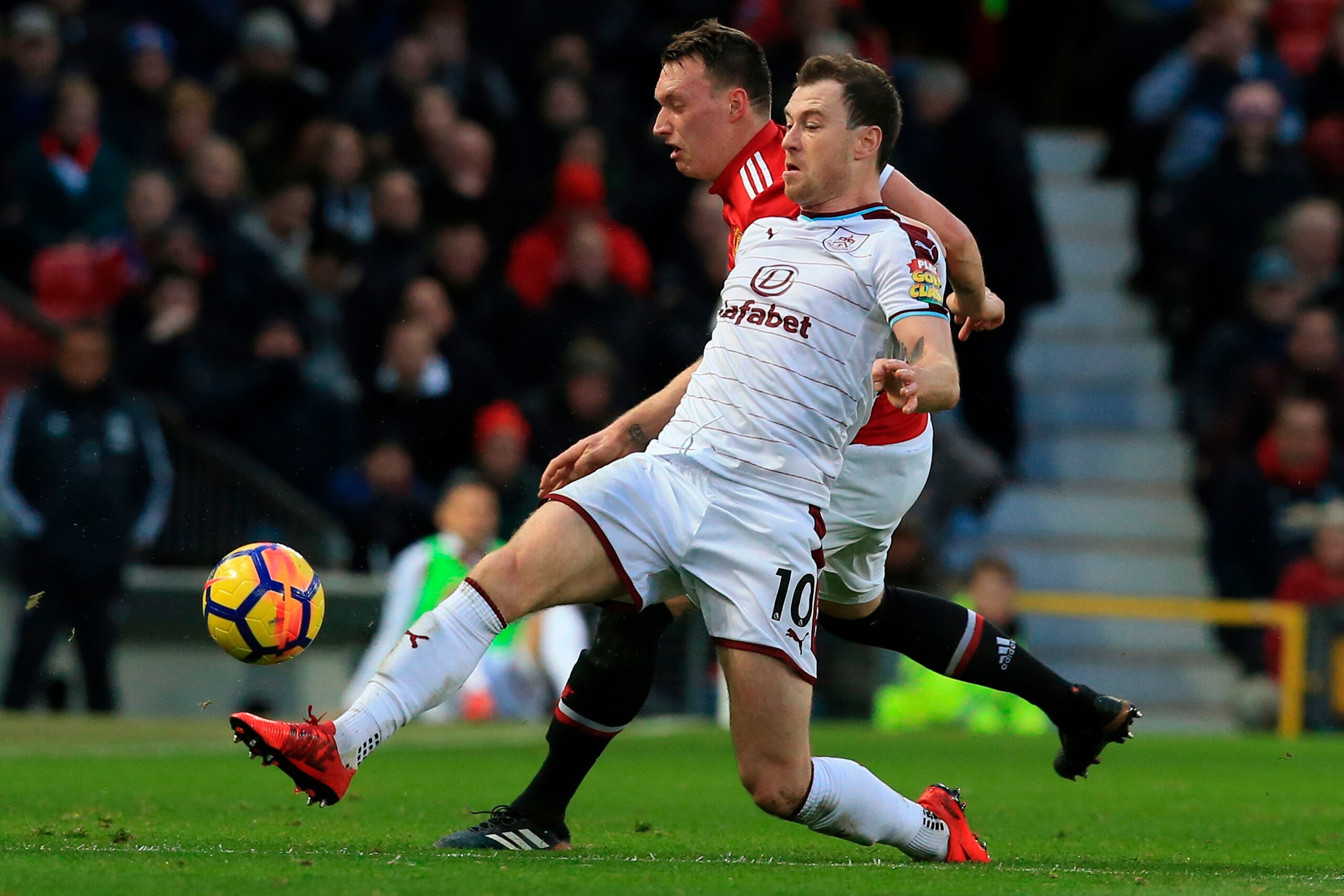 Manchester United's English defender Phil Jones (back) challenges Burnley's English striker Ashley Barnes (front) during the English Premier League football match between Manchester United and Burnley at Old Trafford in Manchester, north west England, on 