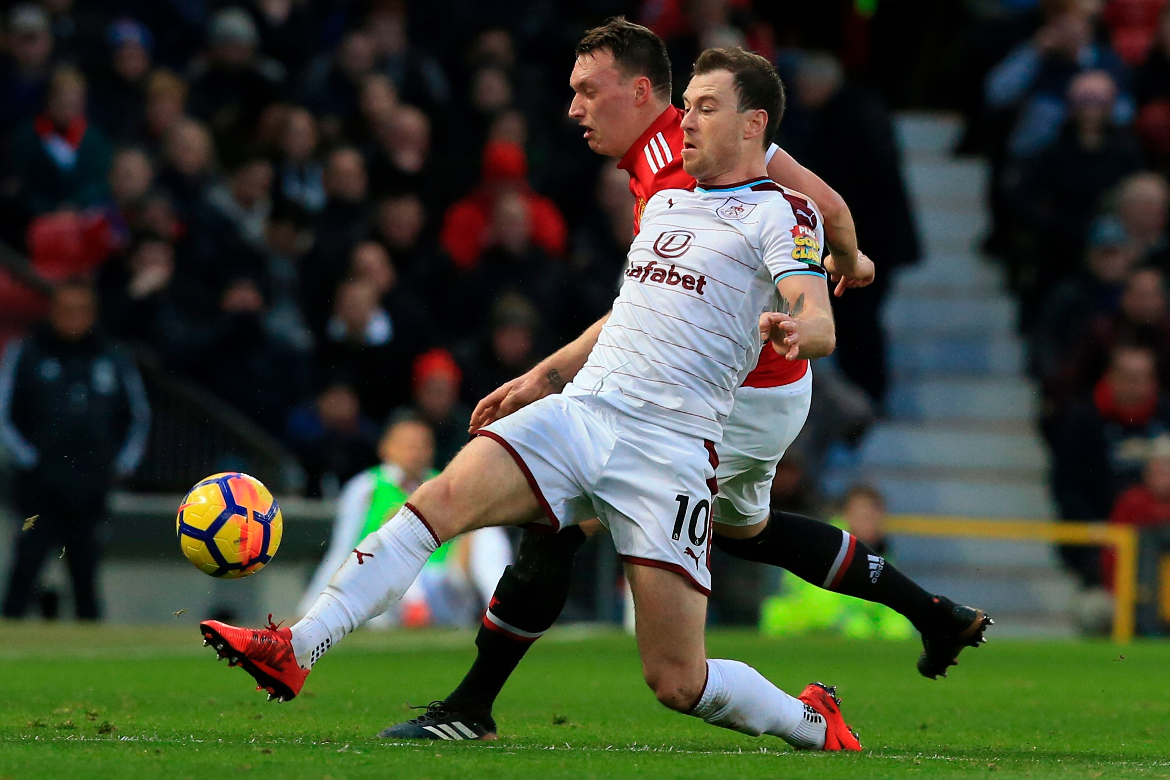 Manchester United's English defender Phil Jones (back) challenges Burnley's English striker Ashley Barnes (front) during the English Premier League football match between Manchester United and Burnley at Old Trafford in Manchester, north west England, on 