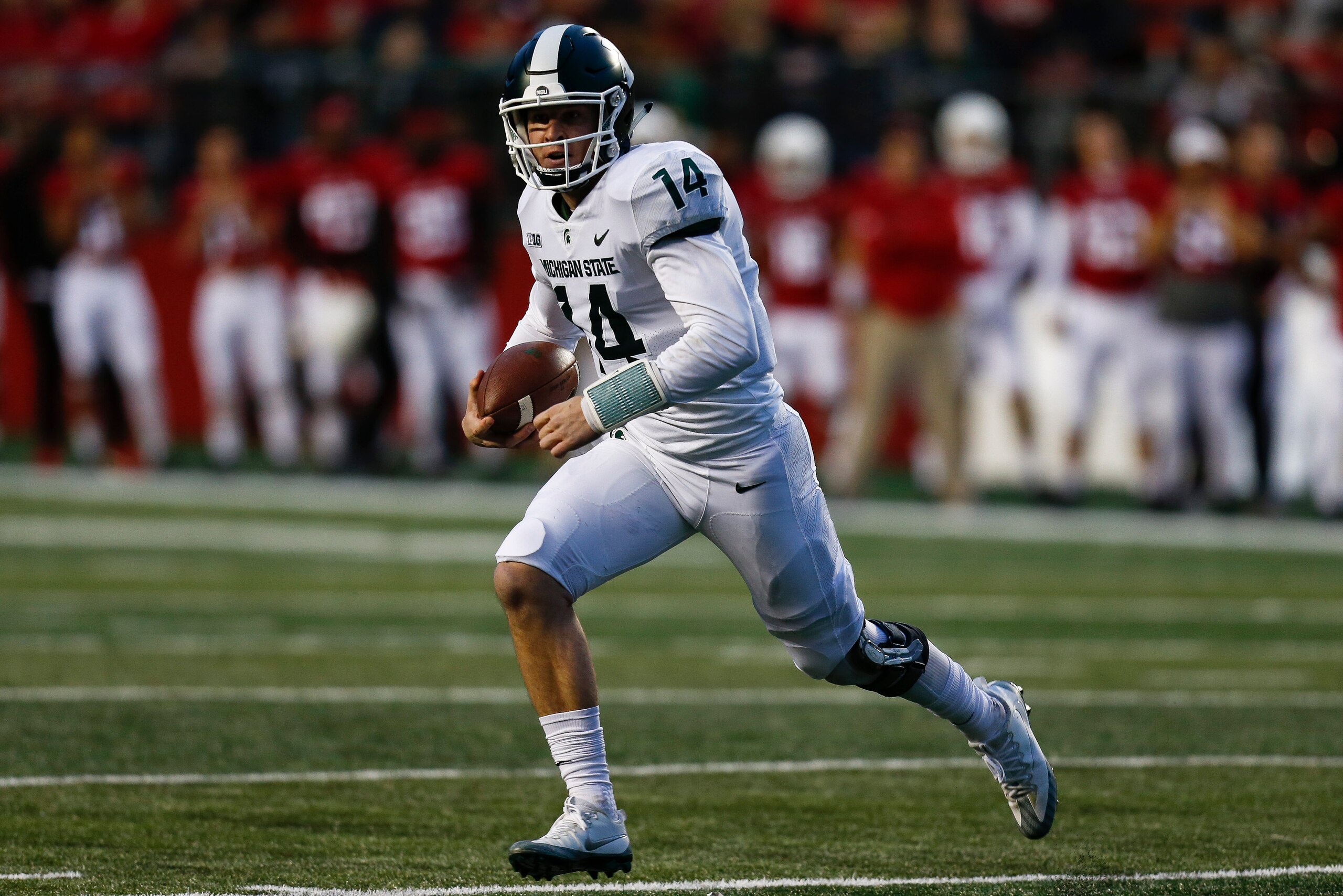 PISCATAWAY, NJ - NOVEMBER 25: Brian Lewerke #14 of the Michigan State Spartans rolls out against the Rutgers Scarlet Knights during their game on November 25, 2017 in Piscataway, New Jersey. (Photo by Jeff Zelevansky/Getty Images)