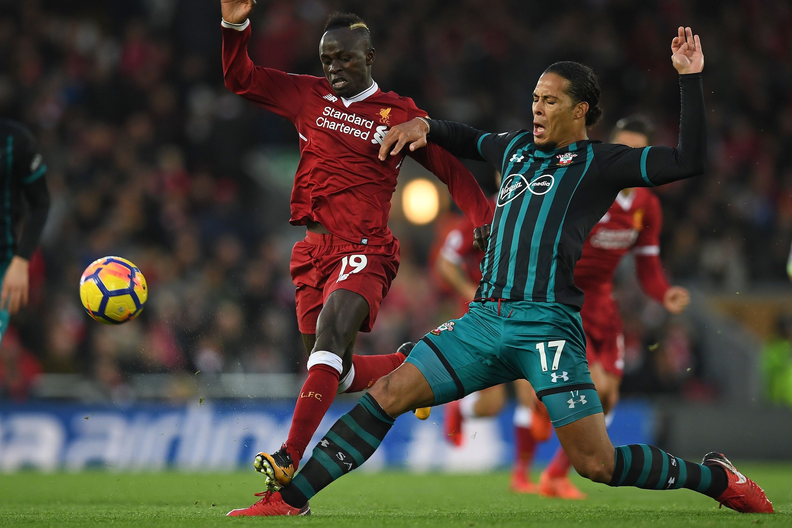 Southampton's Dutch defender Virgil van Dijk (R) vies with Liverpool's Senegalese midfielder Sadio Mane during the English Premier League football match between Liverpool and Southampton at Anfield in Liverpool, north west England on November 18, 2017. / 
