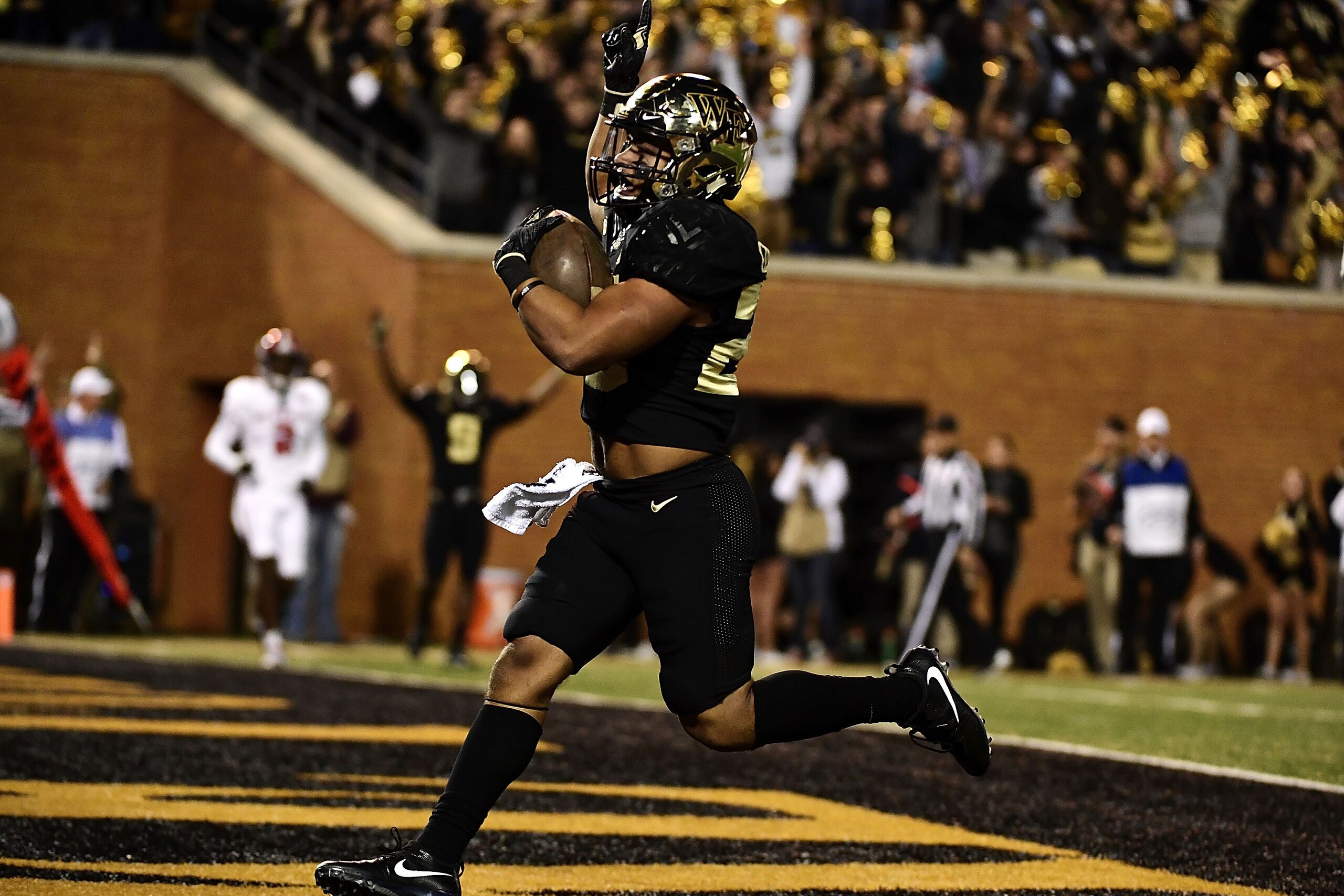 WINSTON SALEM, NC - NOVEMBER 18:  Running back Matt Colburn #22 of the Wake Forest Demon Deacons rushes for a touchdown in the first quarter of the Deacons' football game against the North Carolina State Wolfpack at BB&T Field on November 18, 2017 in Wins