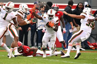 RALEIGH, NC - NOVEMBER 19: Jaquan Johnson #4 of the Miami Hurricanes celebrates following a fumble recovery against Bra'Lon Cherry #13 of the North Carolina State Wolfpack at Carter-Finley Stadium on November 19, 2016 in Raleigh, North Carolina. Miami won