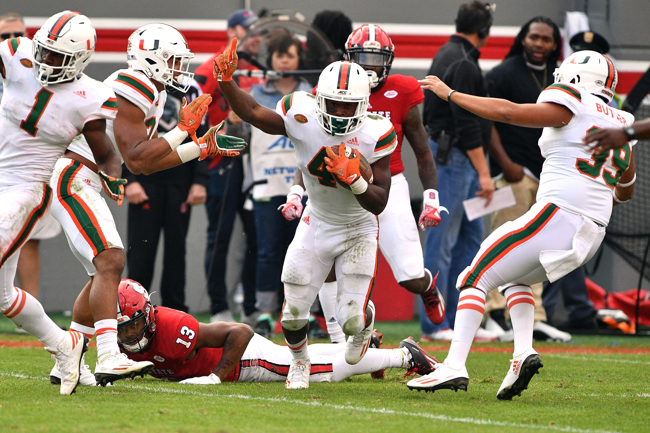 RALEIGH, NC - NOVEMBER 19: Jaquan Johnson #4 of the Miami Hurricanes celebrates following a fumble recovery against Bra'Lon Cherry #13 of the North Carolina State Wolfpack at Carter-Finley Stadium on November 19, 2016 in Raleigh, North Carolina. Miami won