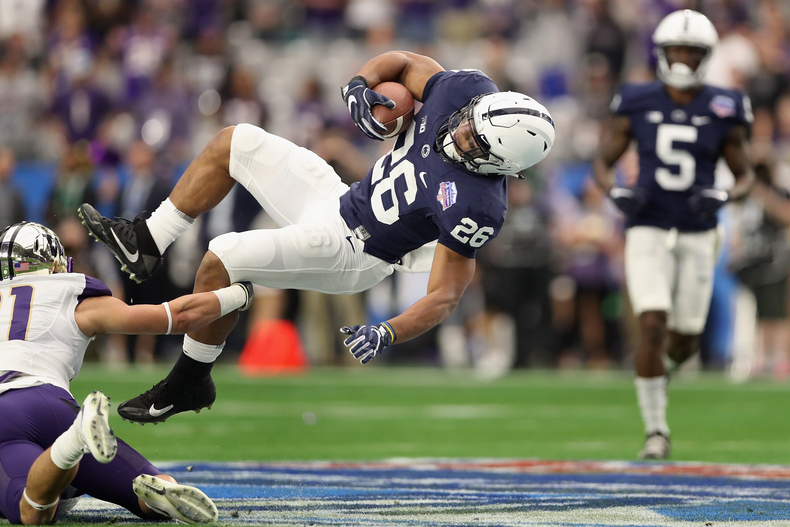 GLENDALE, AZ - DECEMBER 30:  Running back Saquon Barkley #26 of the Penn State Nittany Lions dives with the football as he is tackled by defensive back Taylor Rapp #21 of the Washington Huskies during the first half of the Playstation Fiesta Bowl at Unive