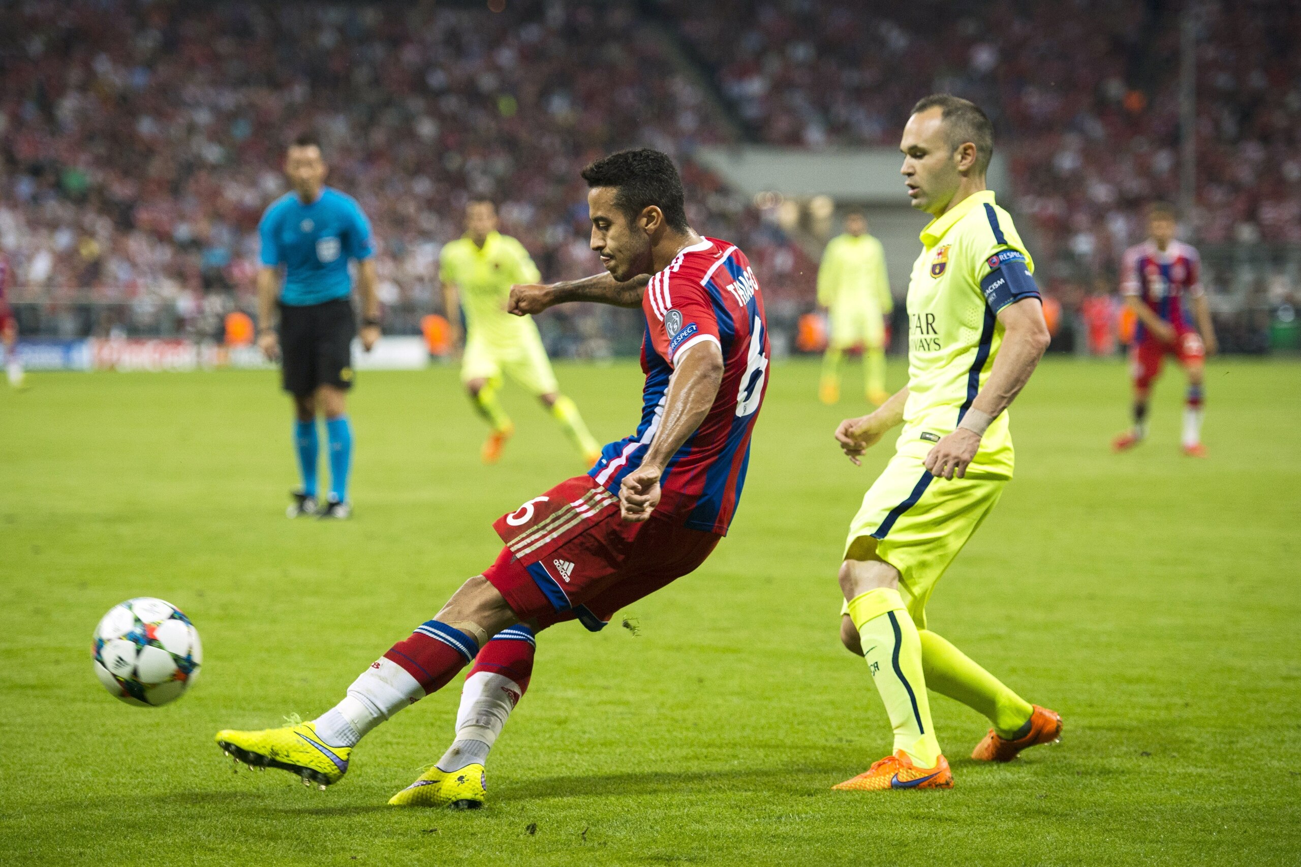 Bayern Munich's Spanish midfielder Thiago Alcantara  (L)  plays a pass challenged by Barcelona's midfielder Andres Iniesta during the UEFA Champions League semi-final second leg football match FC Bayern Munich vs FC Barcelona in Munich, southern Germany, 