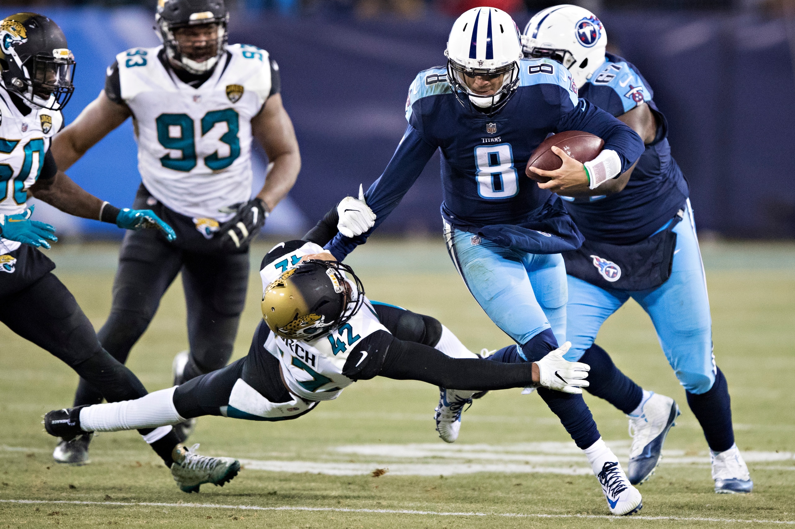 NASHVILLE, TN - DECEMBER 31:  Marcus Mariota #8 of the Tennessee Titans runs the ball and stiff arms Barry Church #42 of the Jacksonville Jaguars at Nissan Stadium on December 31, 2017 in Nashville, Tennessee.  The Titans defeated the Jaguars 15-10.  (Pho