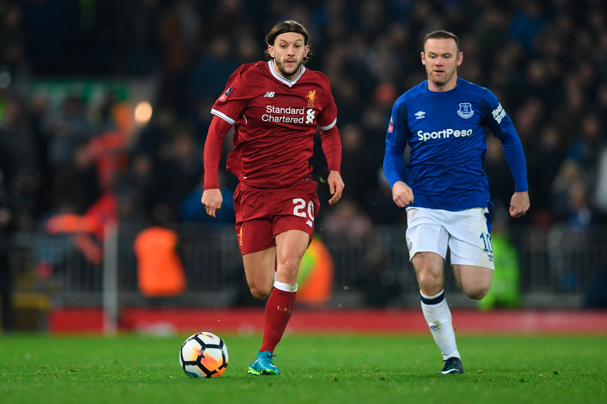 Liverpool's English midfielder Adam Lallana (L) runs away from Everton's English striker Wayne Rooney (R) during the English FA Cup third round football match between Liverpool and Everton at Anfield in Liverpool, north west England on January 5, 2018. / 