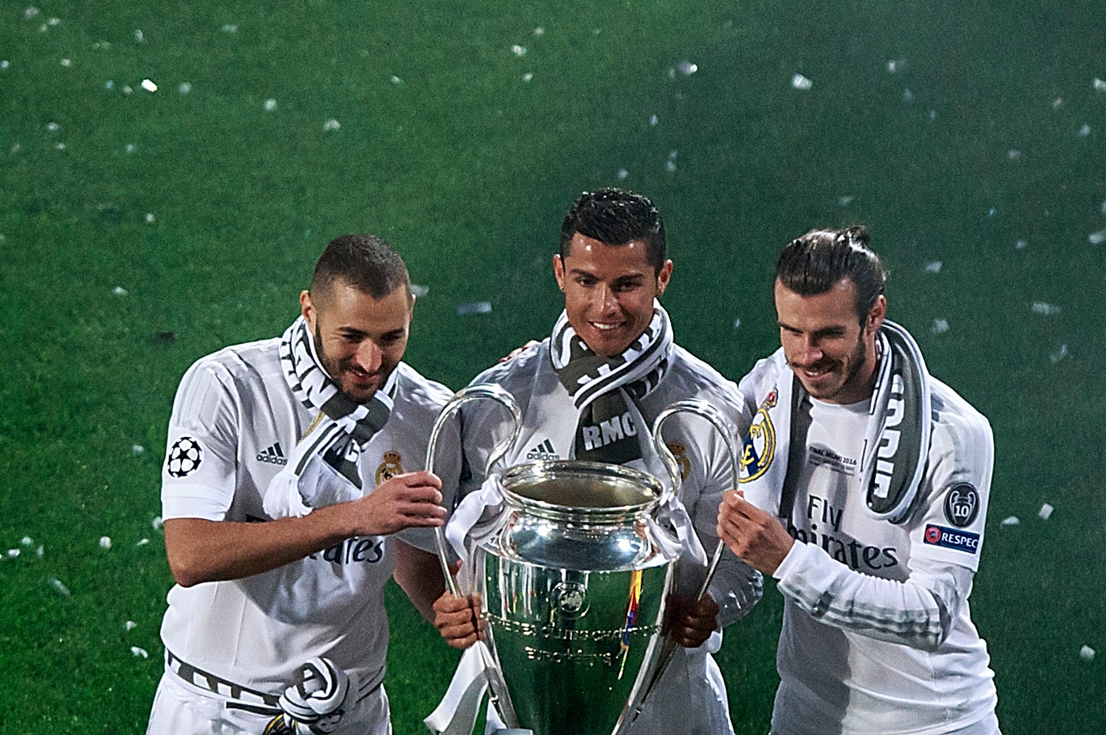 MADRID, SPAIN - MAY 29: Cristiano Ronaldo (2ndL) of Real Madrid CF holds the trophy as he poses for a picture with his teammates Karim Benzema (L) and Gareth Bale (R) during the celebration with their fans at Santiago Bernabeu Stadium the day after winnin