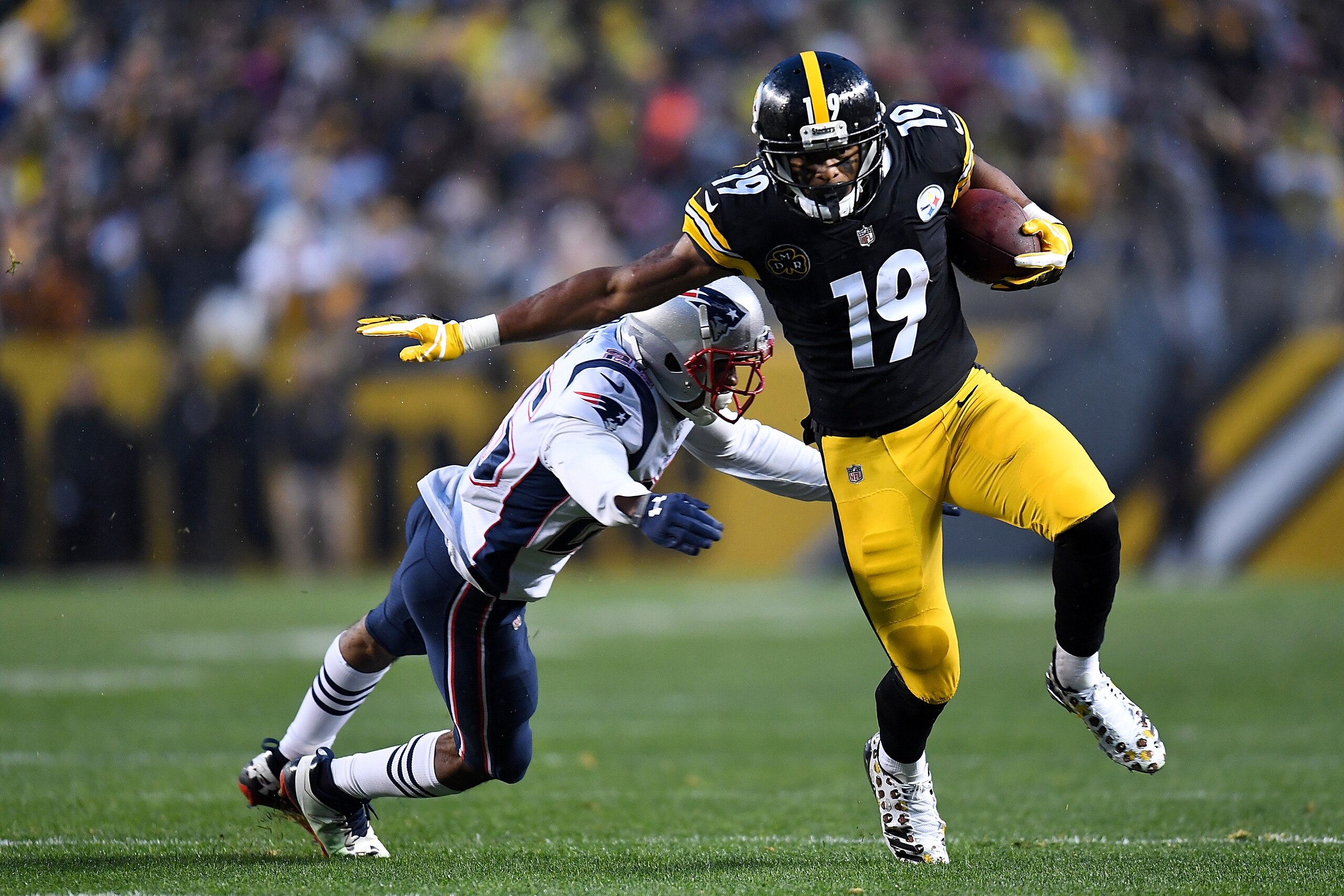 PITTSBURGH, PA - DECEMBER 17: JuJu Smith-Schuster #19 of the Pittsburgh Steelers runs with the ball against Eric Rowe #25 of the New England Patriots after a catch in the first half during the game at Heinz Field on December 17, 2017 in Pittsburgh, Pennsy