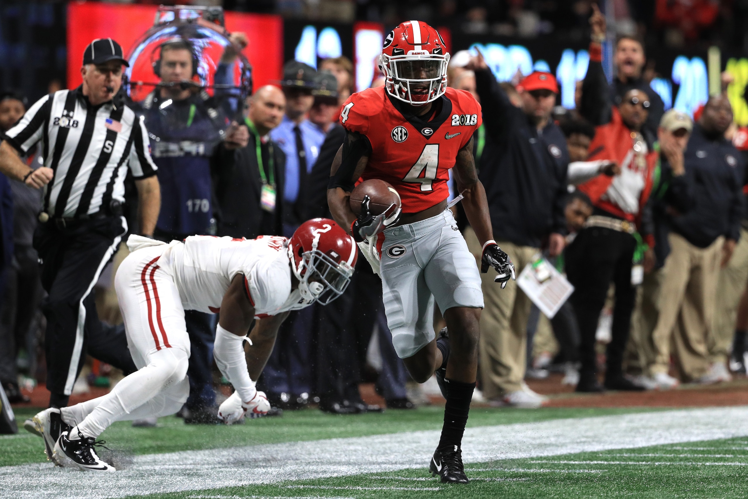 ATLANTA, GA - JANUARY 08: Mecole Hardman #4 of the Georgia Bulldogs manages to stay in bounds for an 80 yard touchdown reception against Tony Brown #2 of the Alabama Crimson Tide during the third quarter in the CFP National Championship presented by AT&T ATLANTA, GA - JANUARY 08: Mecole Hardman #4 of the Georgia Bulldogs manages to stay in bounds for an 80 yard touchdown reception against Tony Brown #2 of the Alabama Crimson Tide during the third quarter in the CFP National Championship presented by AT&T